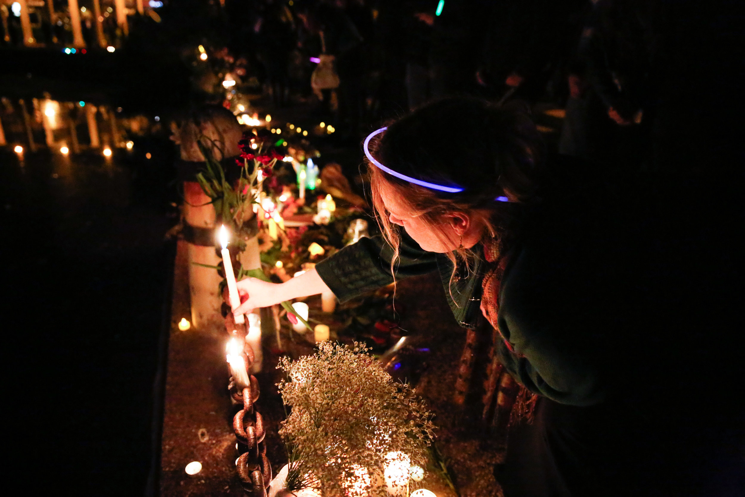  A women places a candle at a memorial site in honor of the 36 people who died in the Oakland Fire at the Ghost Ship warehouse party Friday, December 2.&nbsp; 