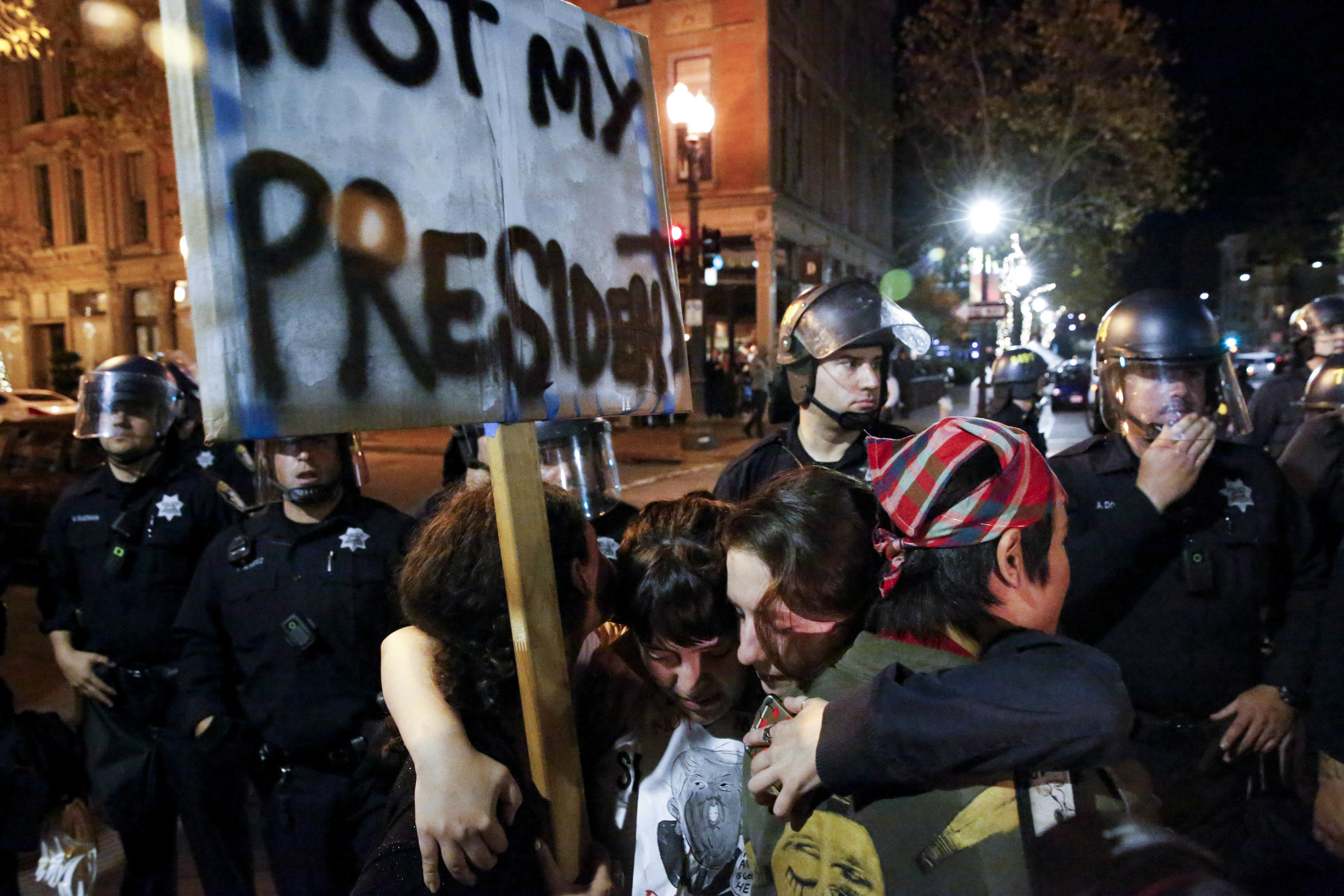 A group of anti-Trump protesters hug each other on Washington Street Oakland, Calif. Wednesday Nov. 9 2016.