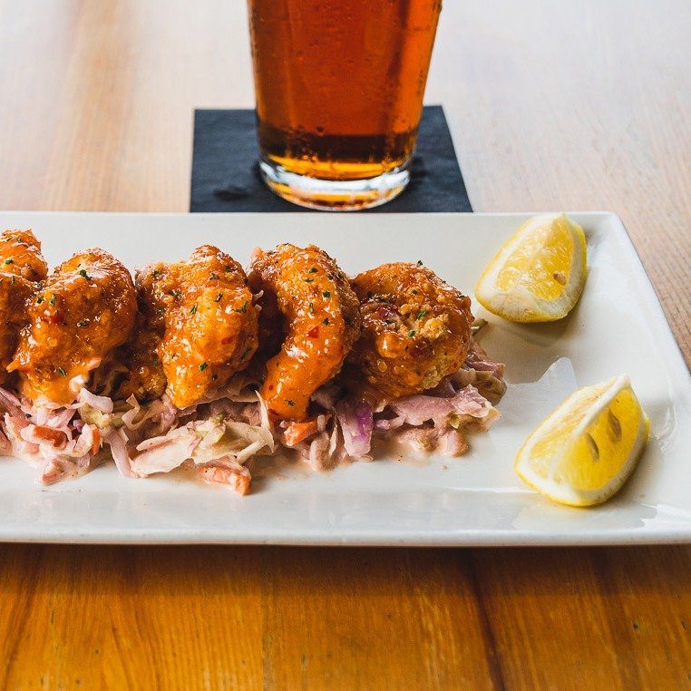 🌶️💥 If your taste buds are screaming for adventure, our Chonburi Shrimp is the answer. These aren't your average fried shrimp; they're a crispy, spicy spectacle served on a bed of crisp Napa slaw. It's the culinary equivalent of a thrill ride... fo