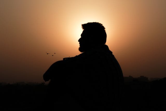 man sitting sunset behind
