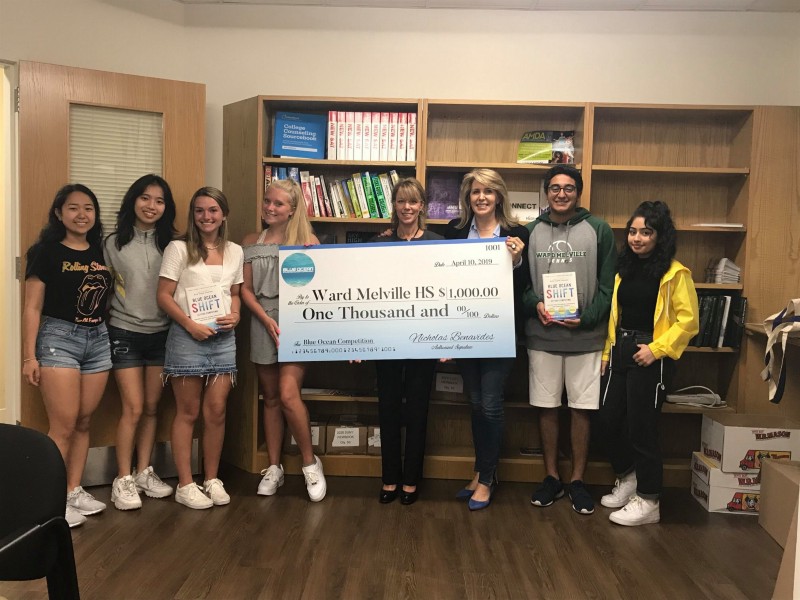 Professor Mauborgne presenting a $1k prize to Business Teacher Ilene Littman and her students at Ward Melville High School in East Setauket, New York.