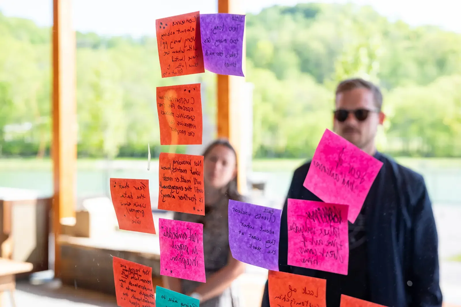 The Ready team working through a brainstorm with colorful sticky notes on a glass wall during a workshop.