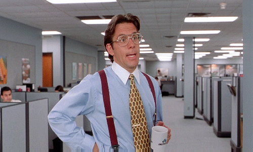 A gif showing the manager from the movie office space standing in a room full of cubicles