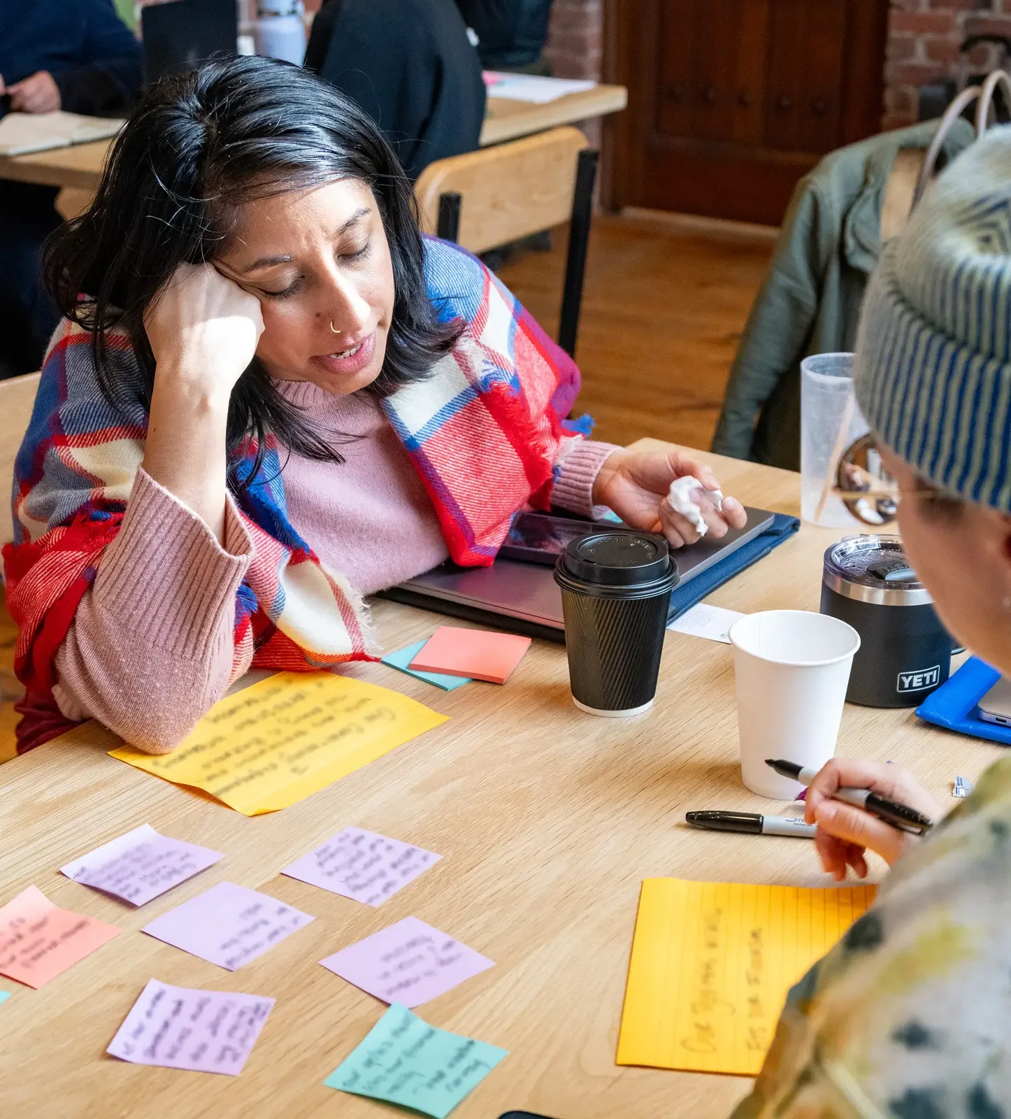 Two women collaborating at a table during a The Ready working session.