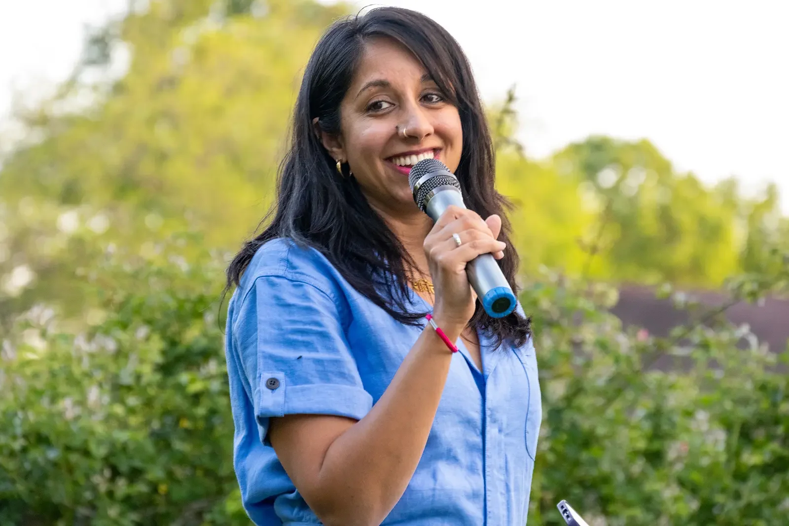 A The Ready consultant speaking at an outdoor event with a microphone.