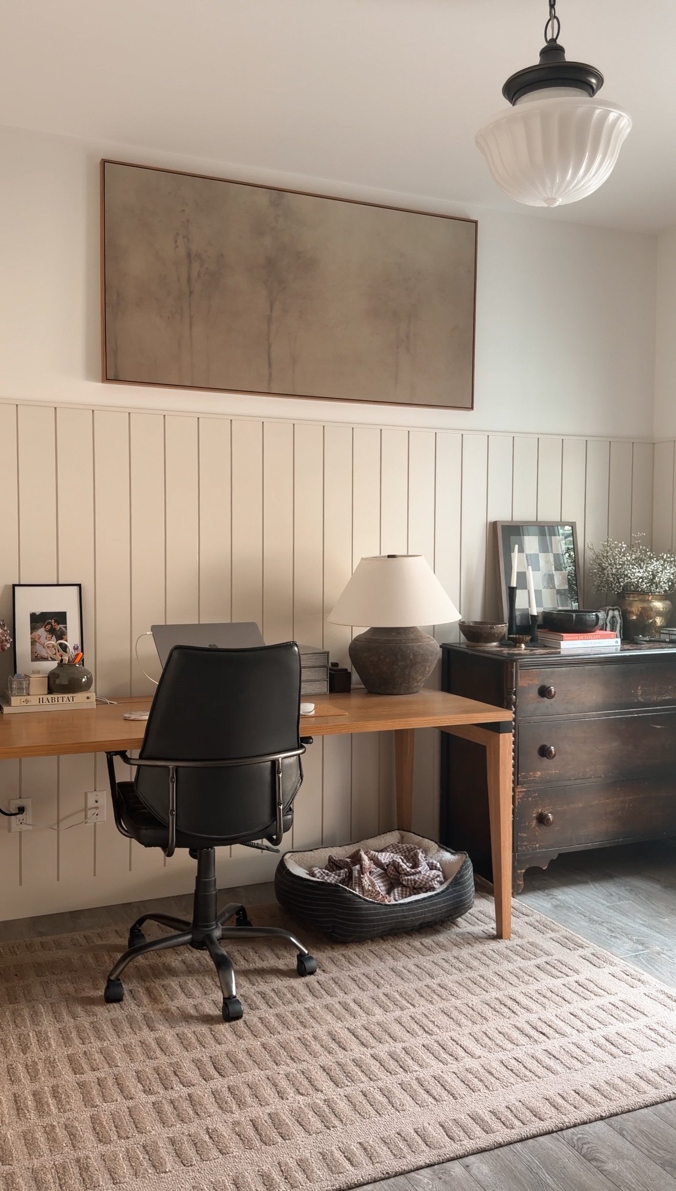Oversized wall art creating a statement above white shiplap in a home office
