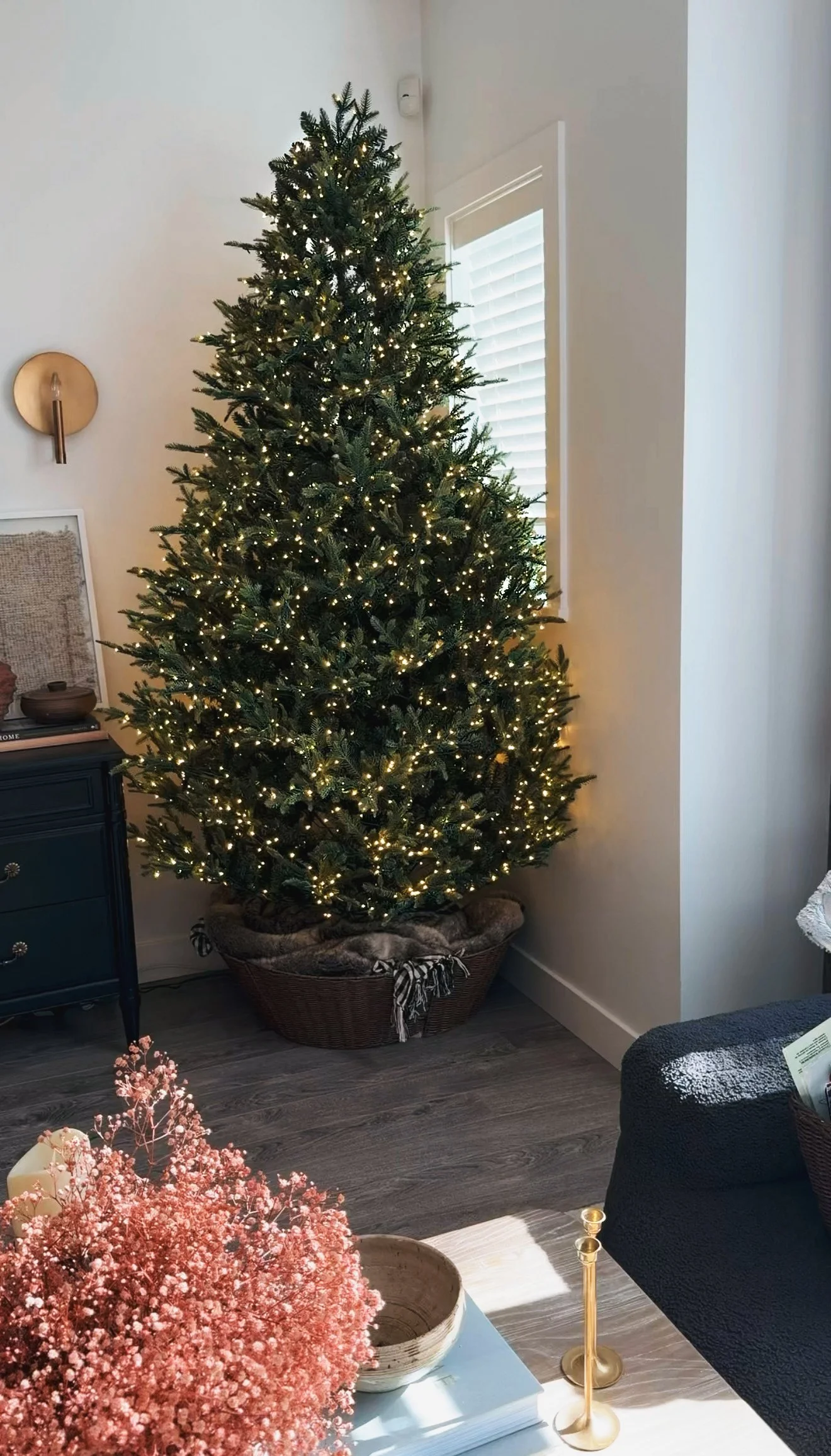 Rattan tree collar hiding a Christmas tree stand in a cozy living room