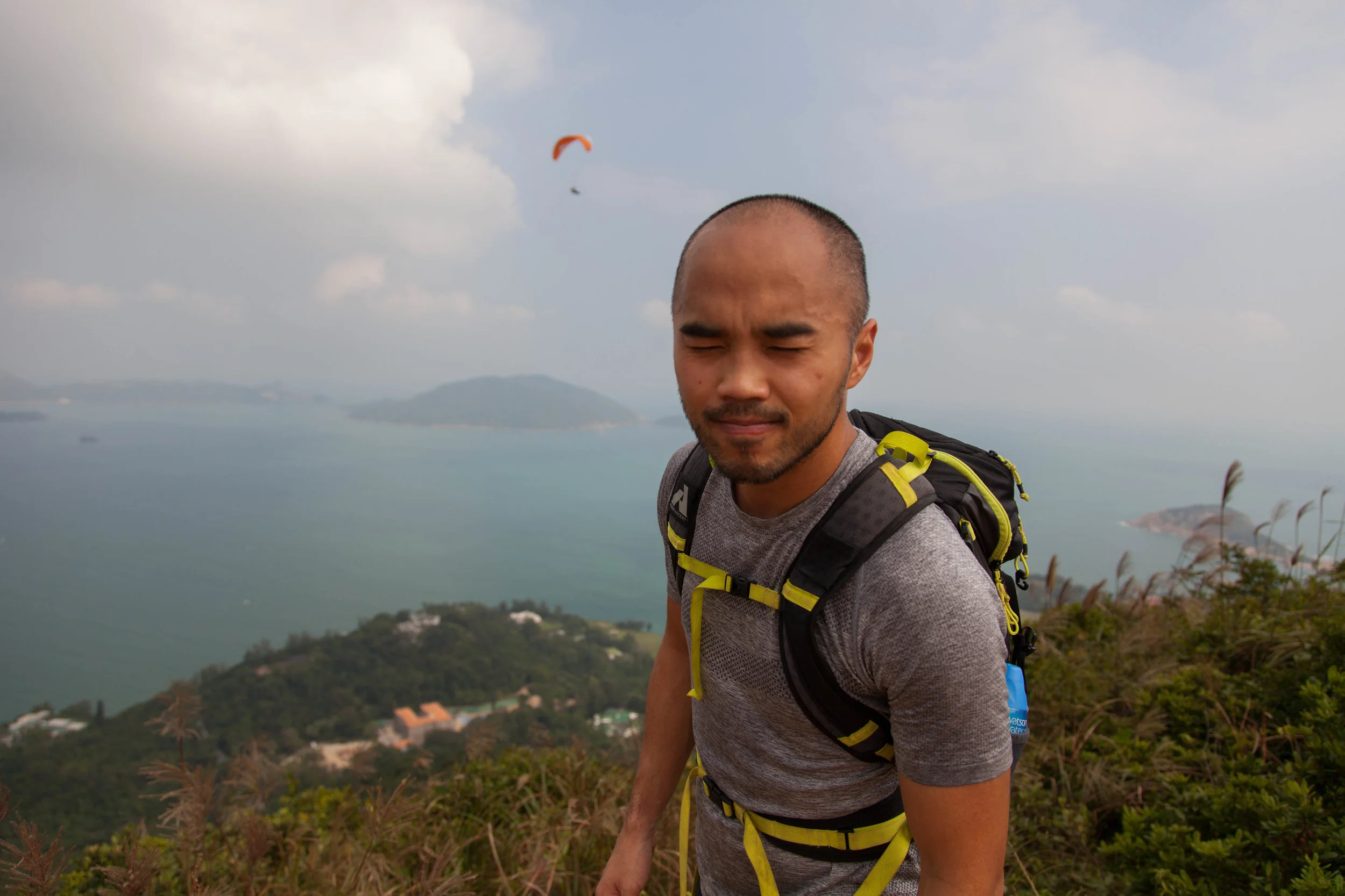 Brian refusing to smile for a photo and a paraglider behind him!