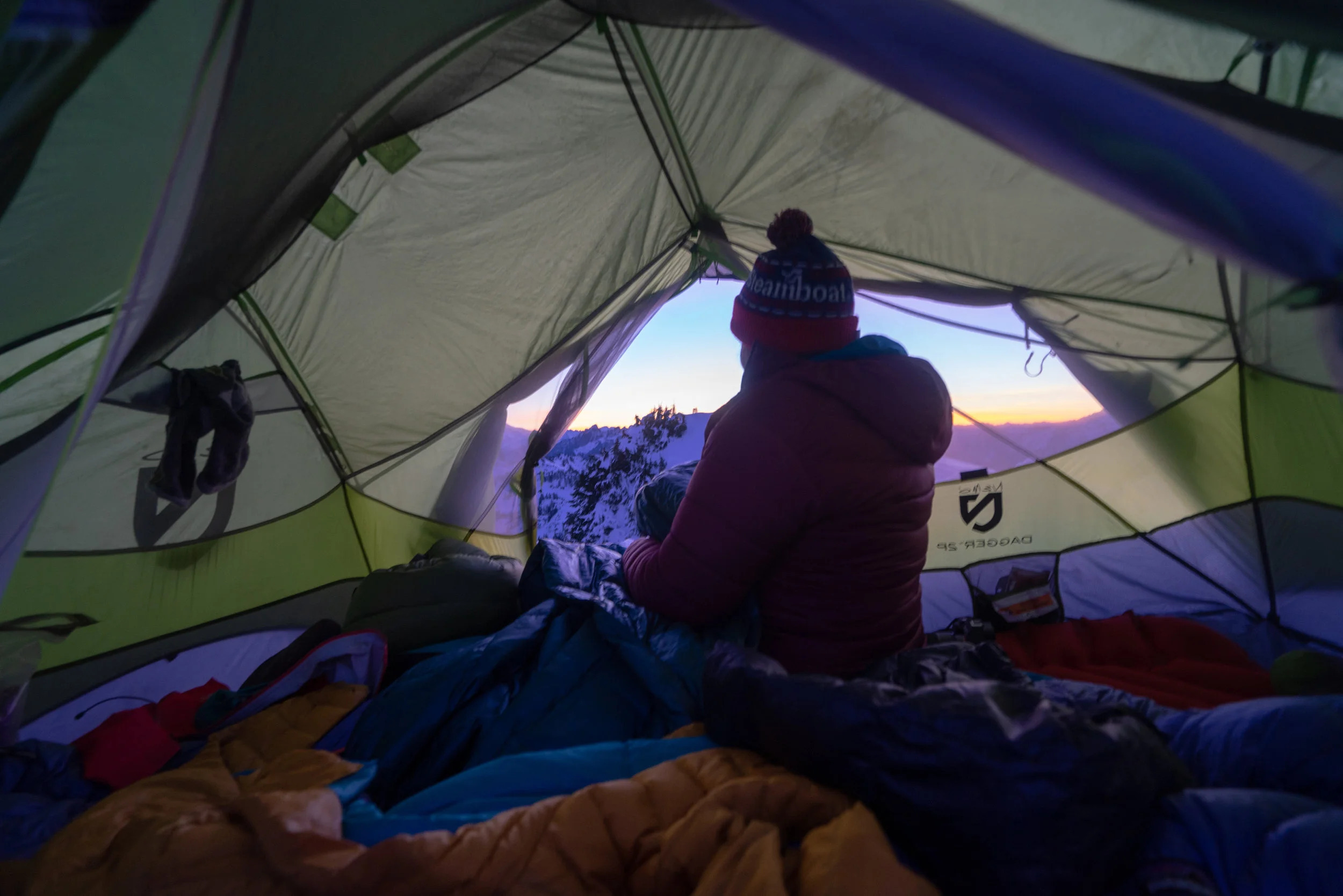 Sarina putting her boots on while the sun starts to rise.