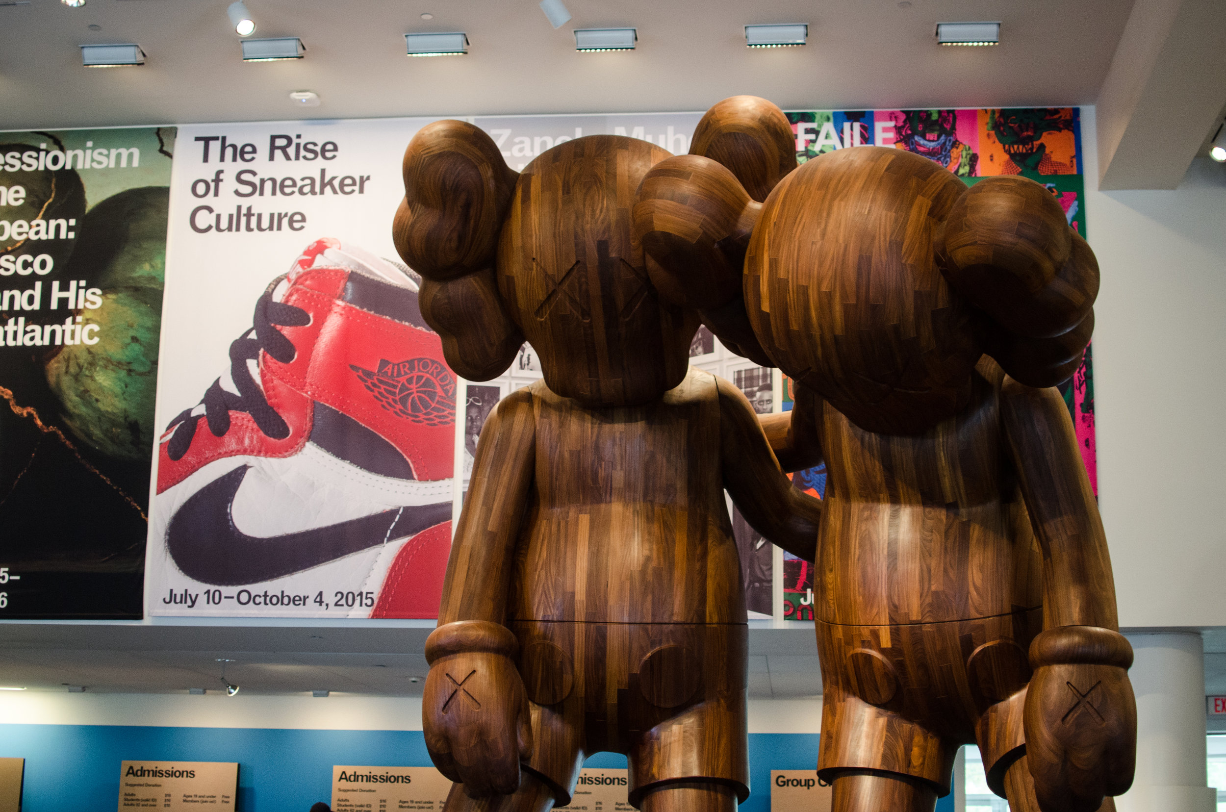 Brooklyn Museum with "The Rise of Sneaker Culture" sign next to two Kaws statues.