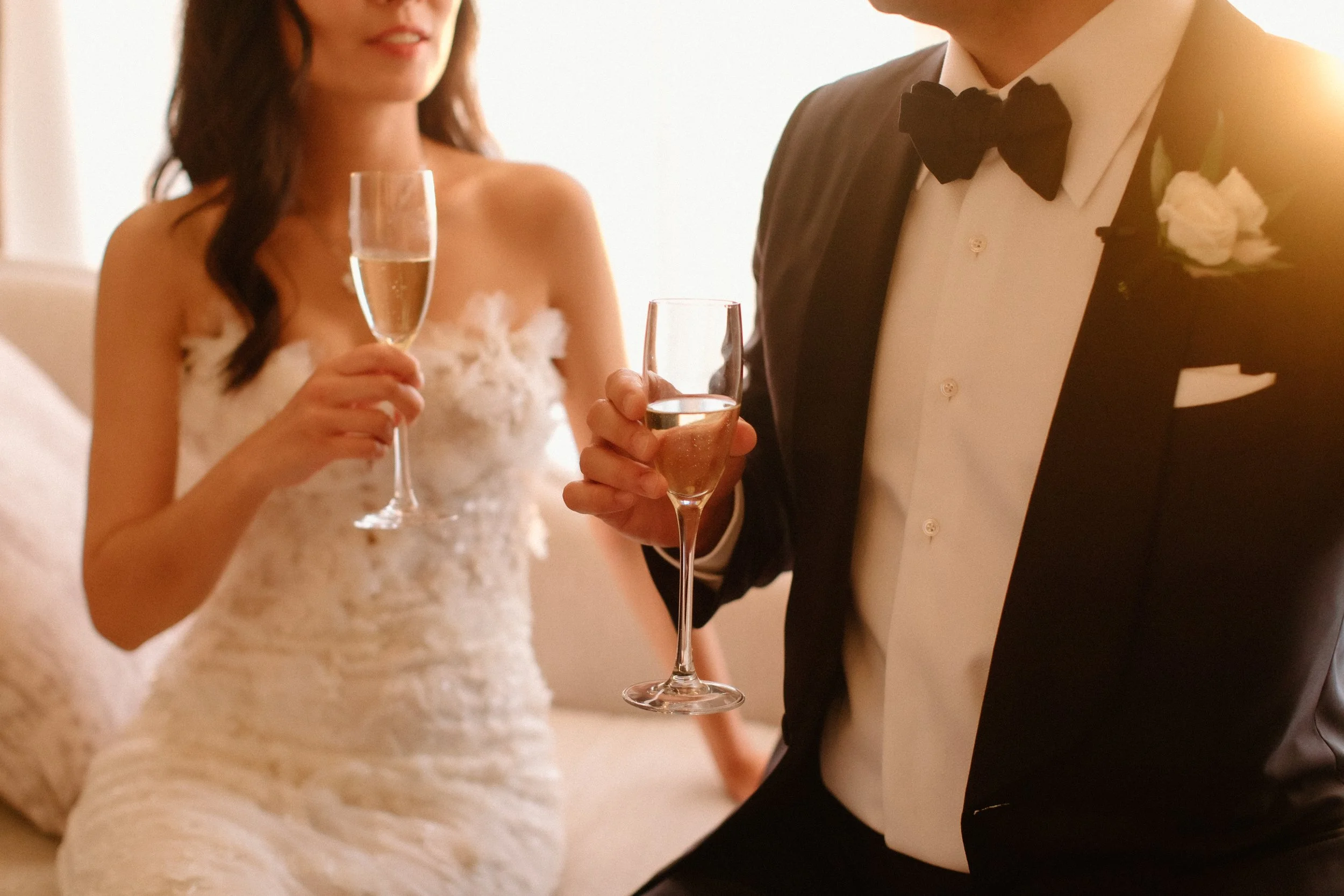 Bride and groom toast with glasses of Dom Perignon, bride wears Pronovias gown