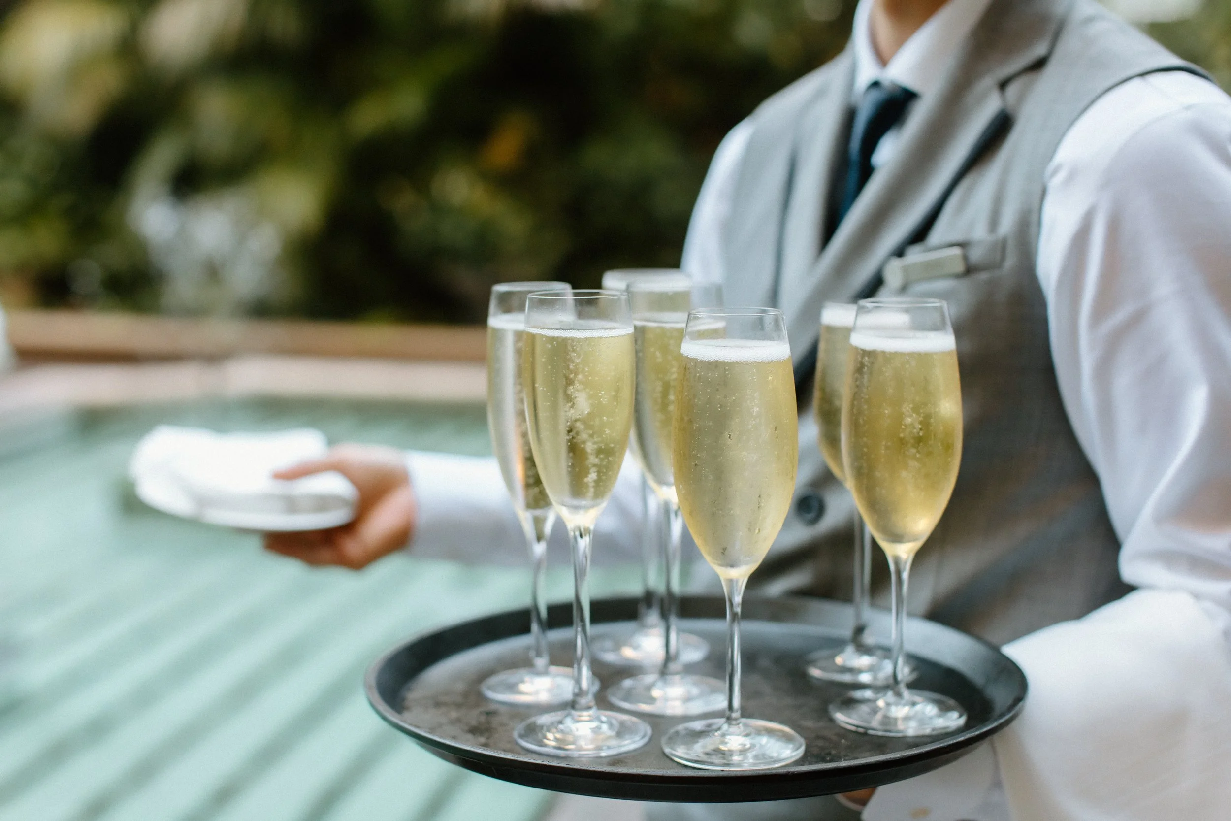 Tray passed Dom Perignon as guests arrive at garden wedding ceremony at Four Seasons Hotel Los Angeles at Beverly Hills