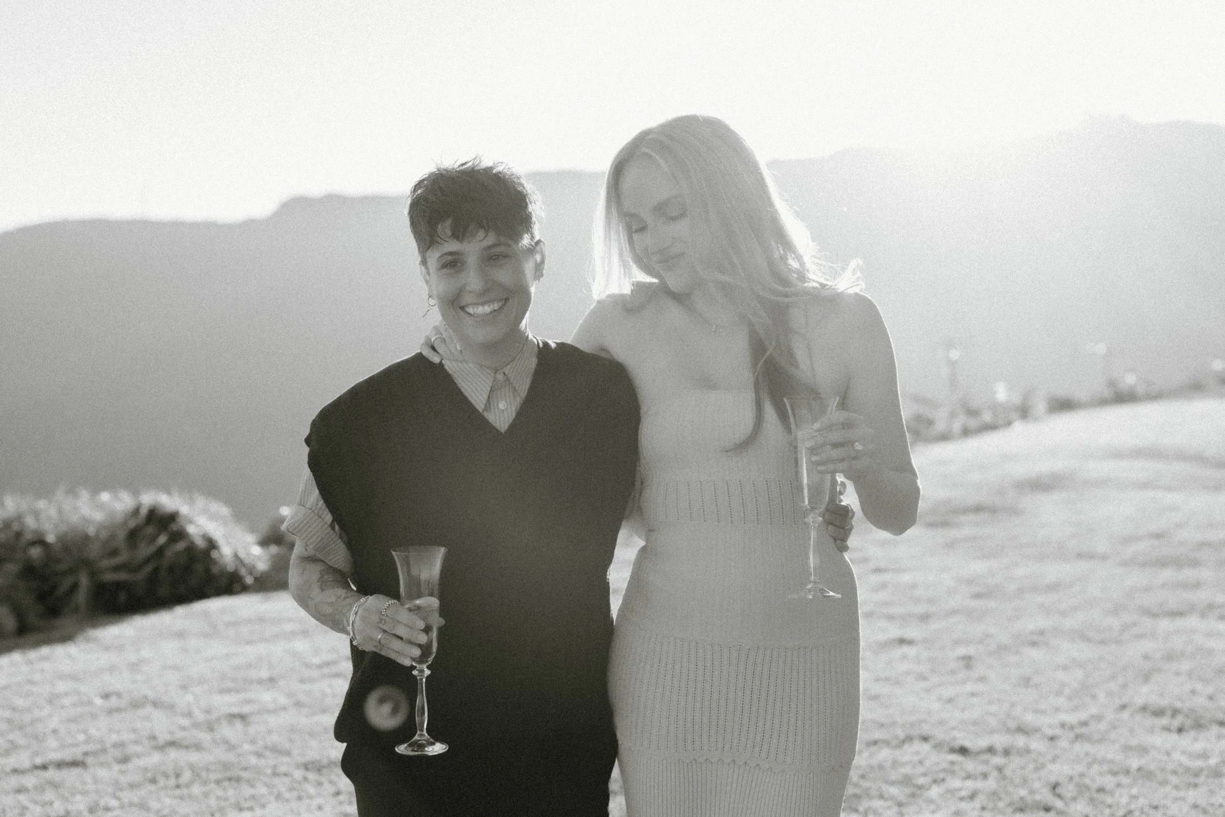 sun drenched black and white image of engaged couple on hillside in Malibu