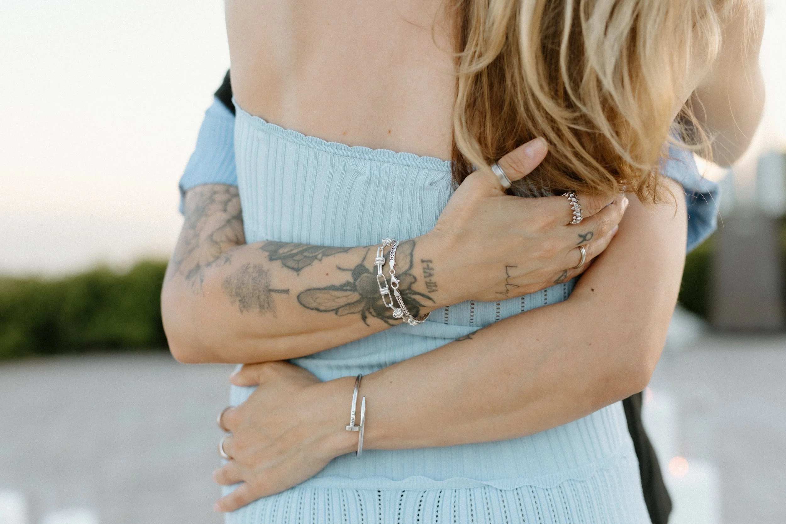 partner with tattoos embraces their love