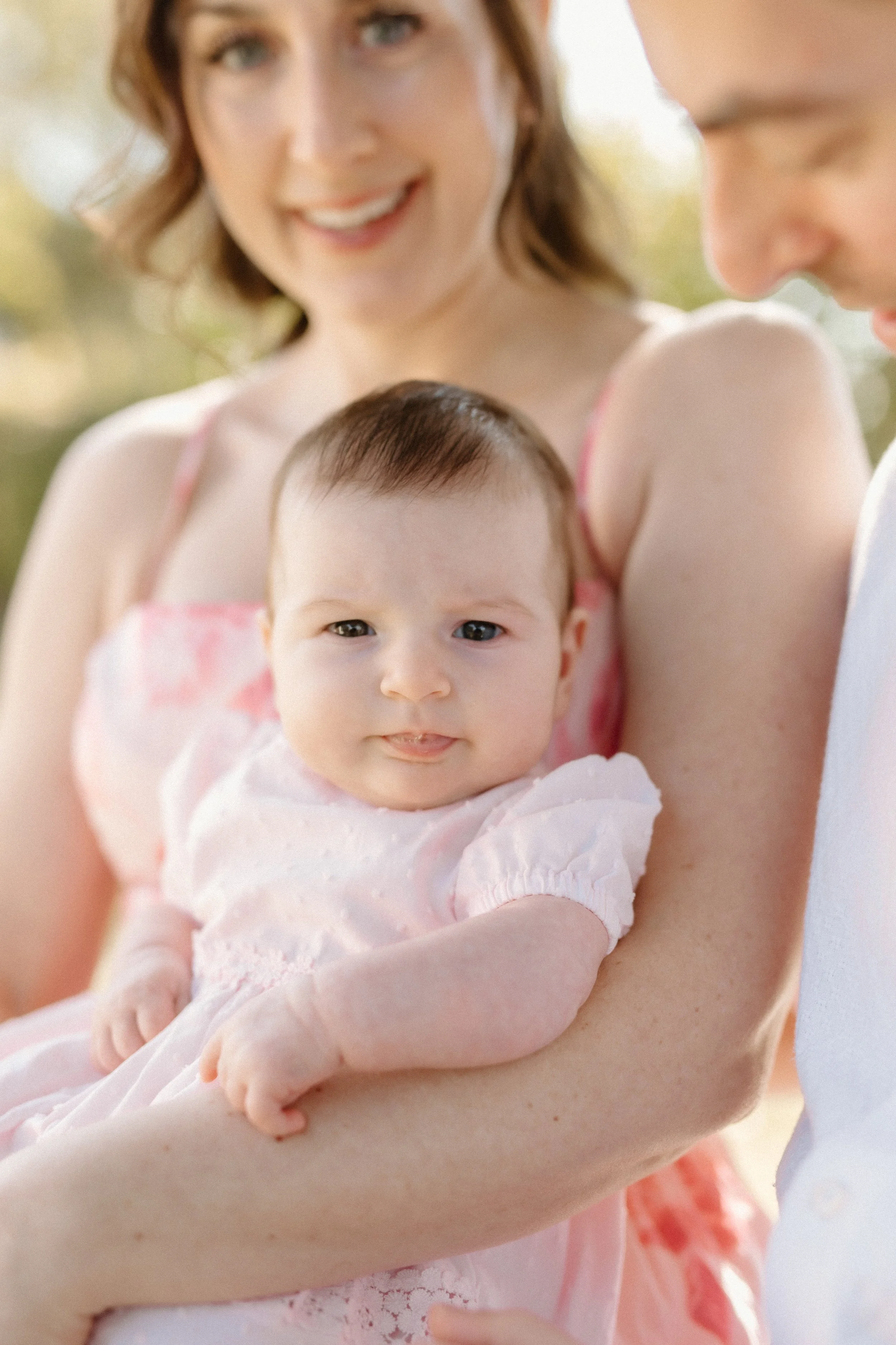 Newborn girl with parents in backyard