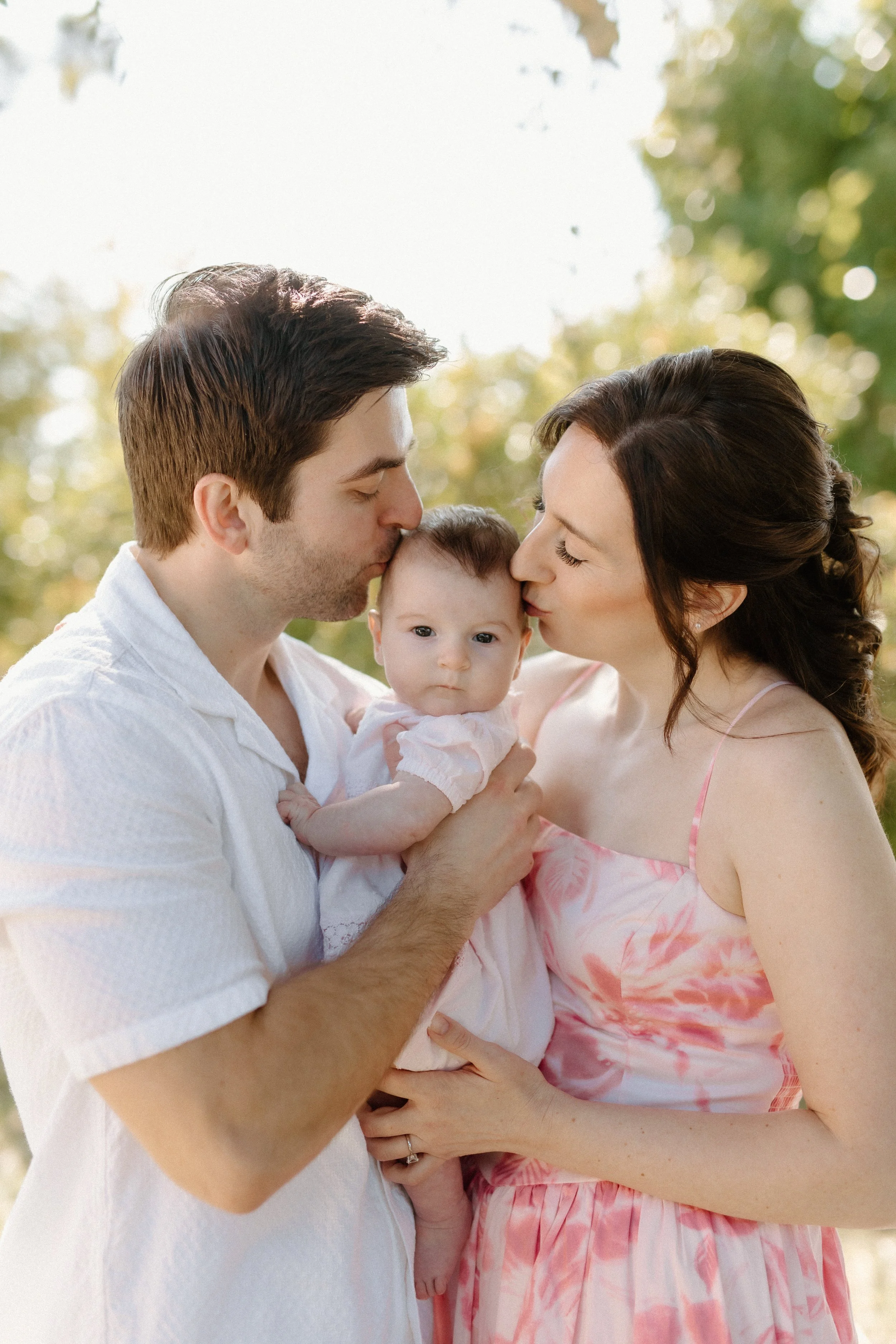 Parents kissing baby 