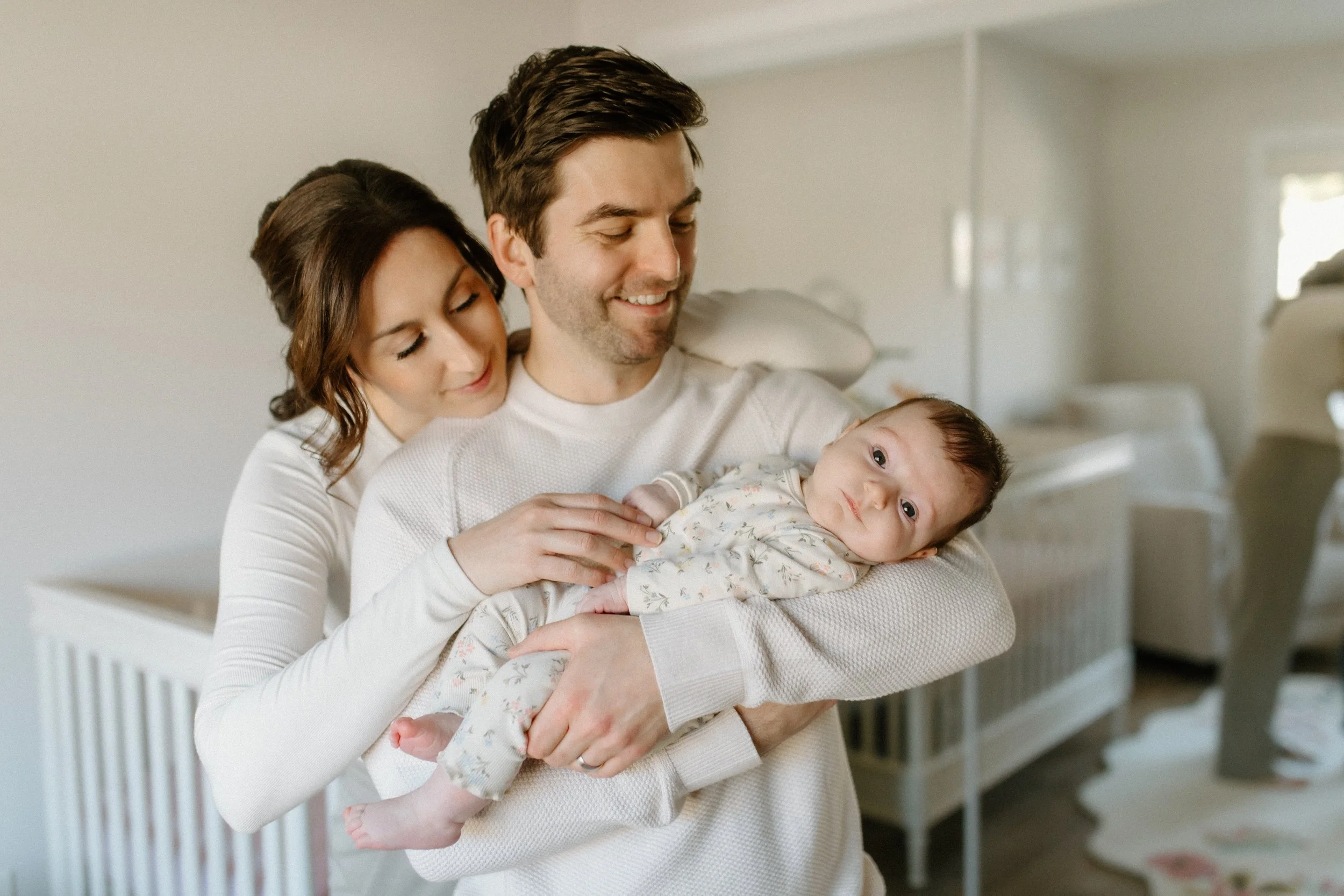Parents cuddling new baby