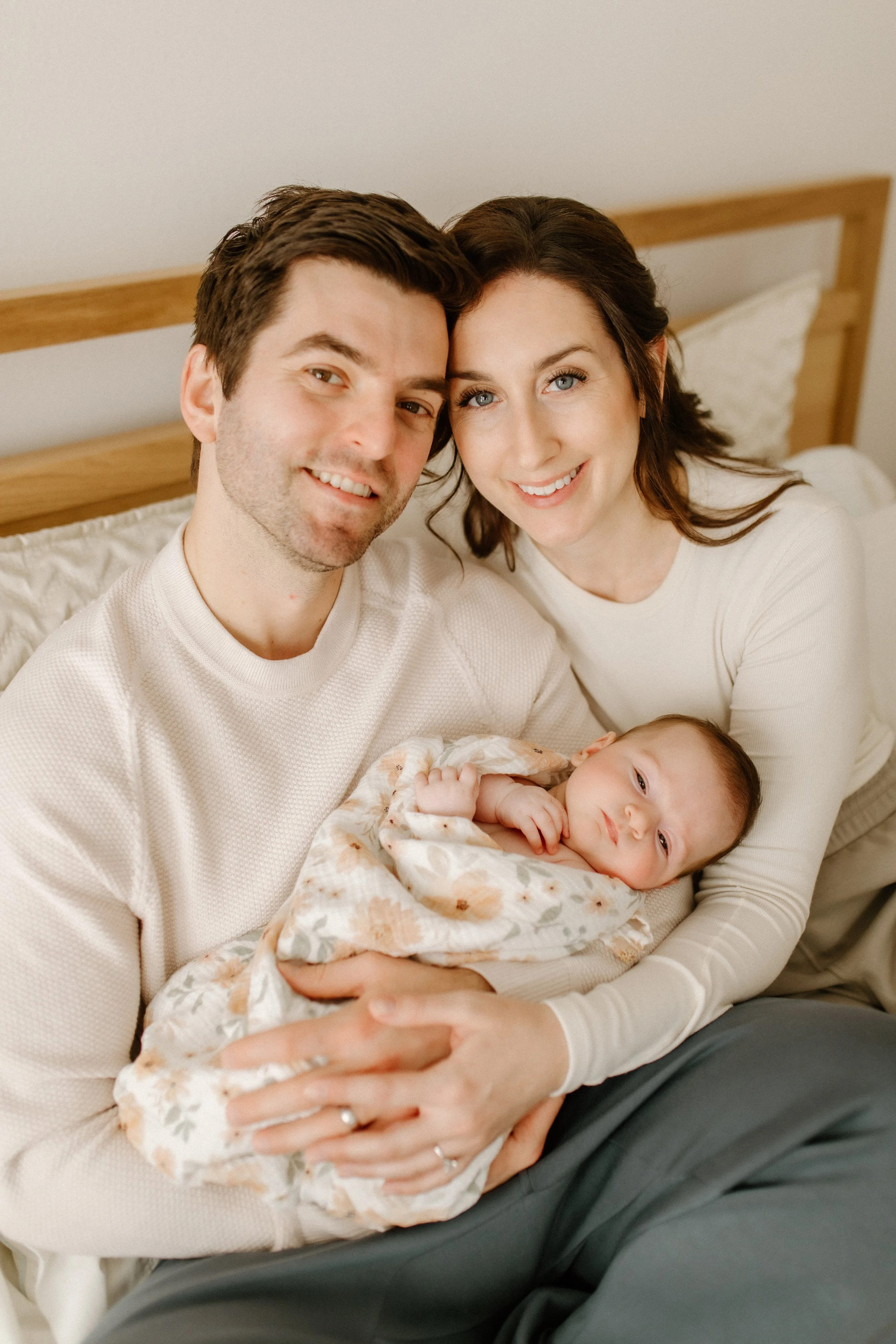 new parents cuddling baby at home