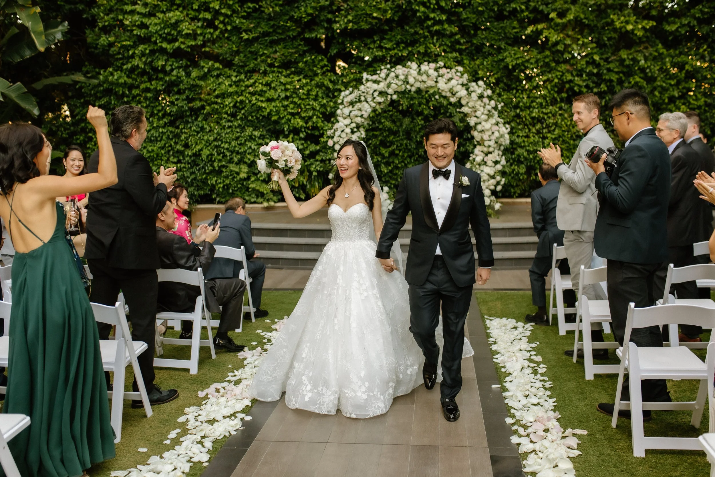 Bride and groom walk down the aisle for the first time as a married couple. Bride in a stunning Pronovias ballgown