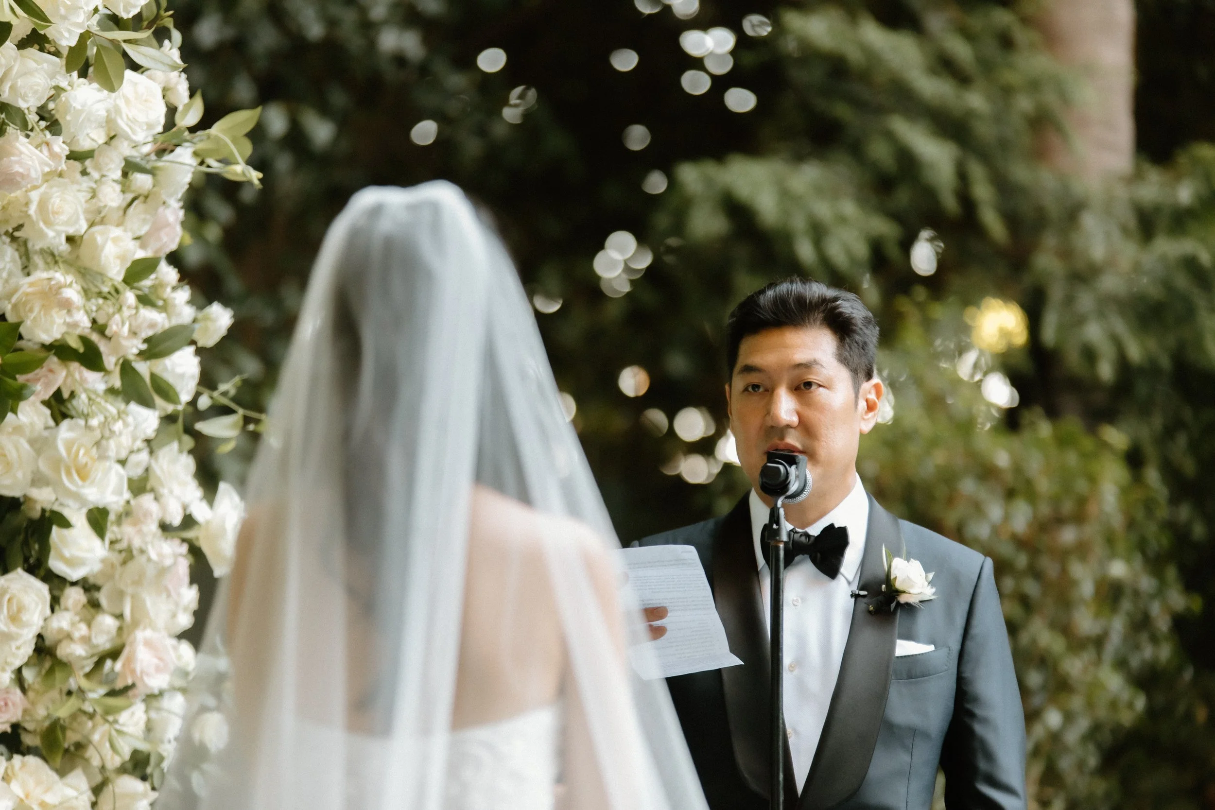 Groom recites vows to bride in garden ceremony at Four Seasons Hotel
