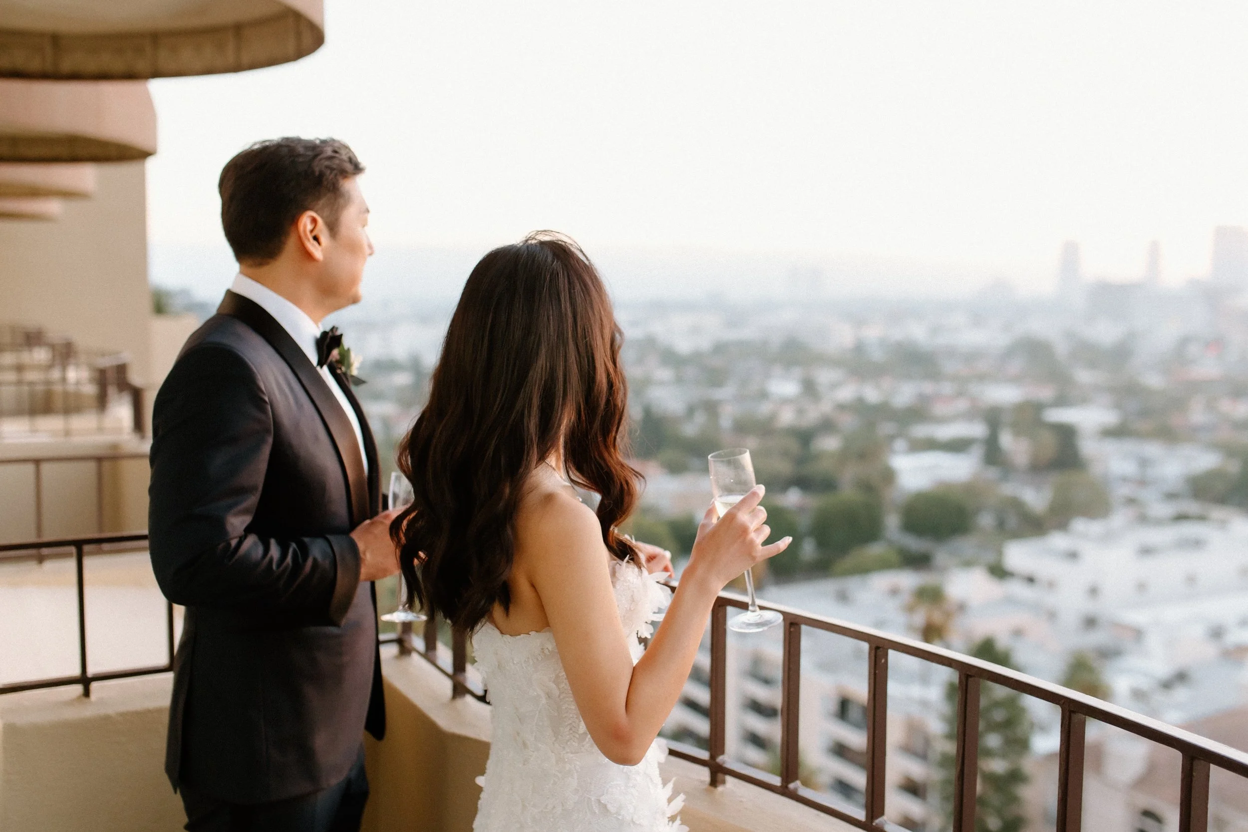 Bride and groom enjoy the Los Angeles vistas on the balcony of their wedding suite at Four Seasons Hotel Los Angeles at Beverly Hills