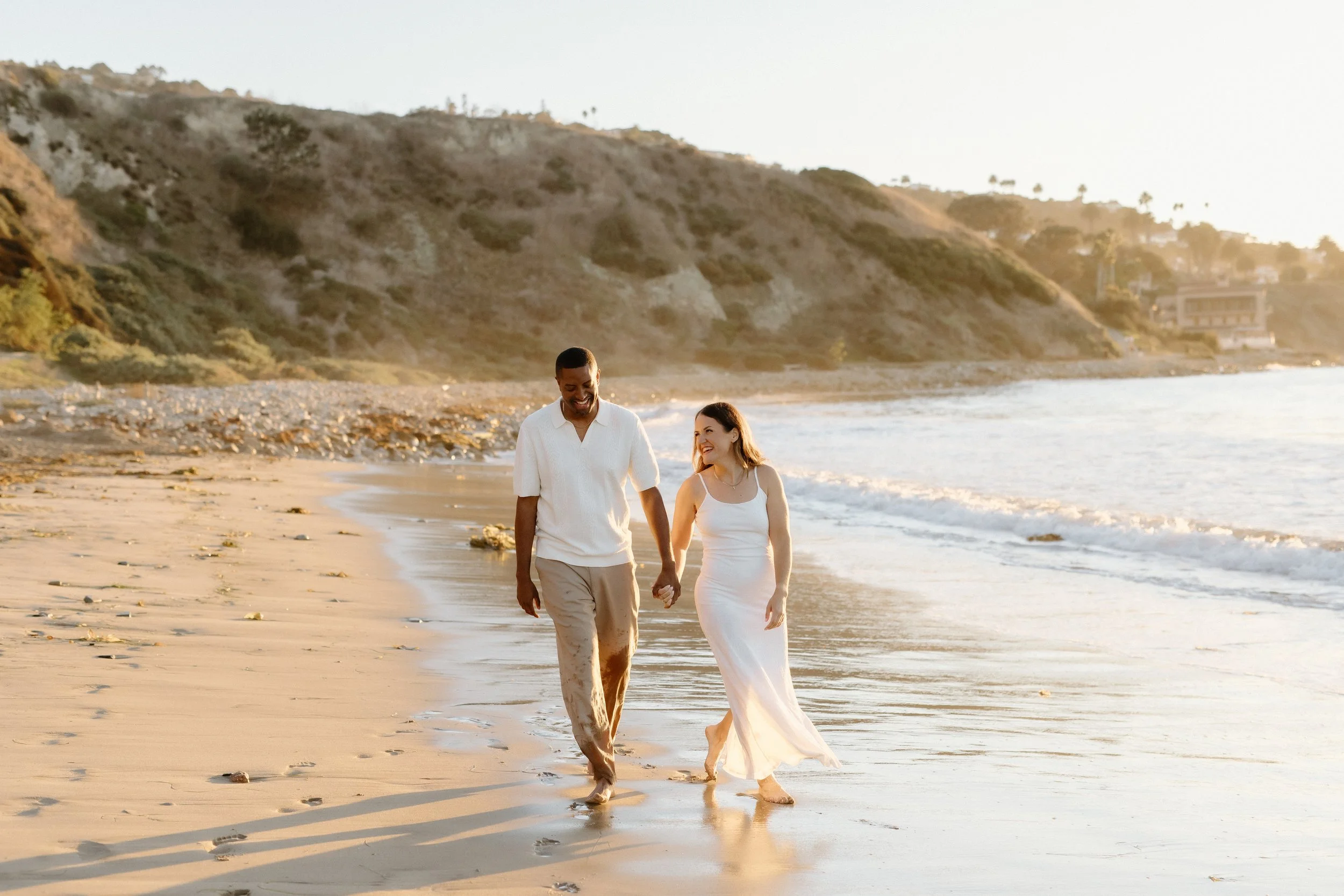 Engaged couple strolls on Palos Verdes Beach during engagement session