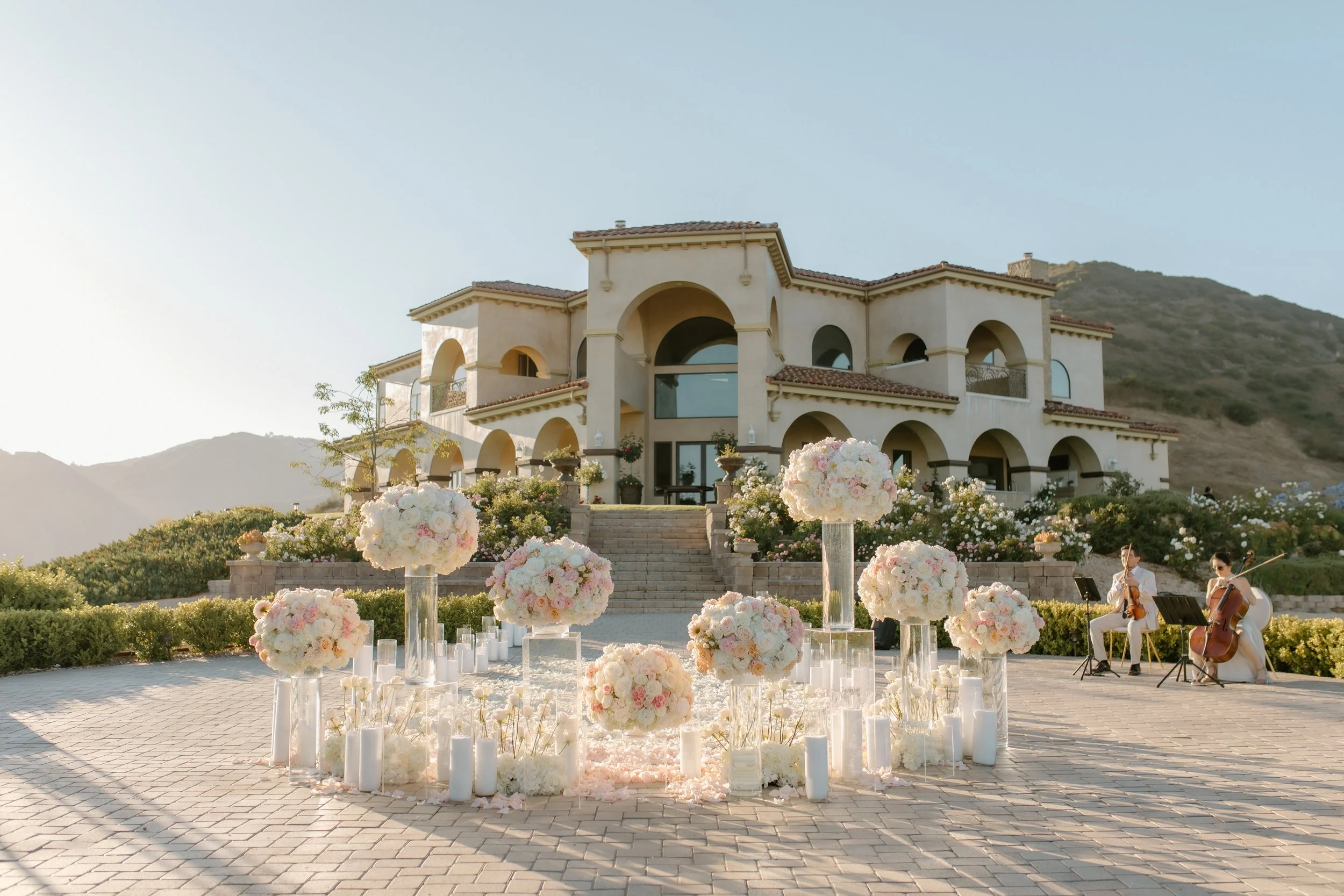 Grand View Malibu luxury proposal with string duo surrounded by roses at sunset