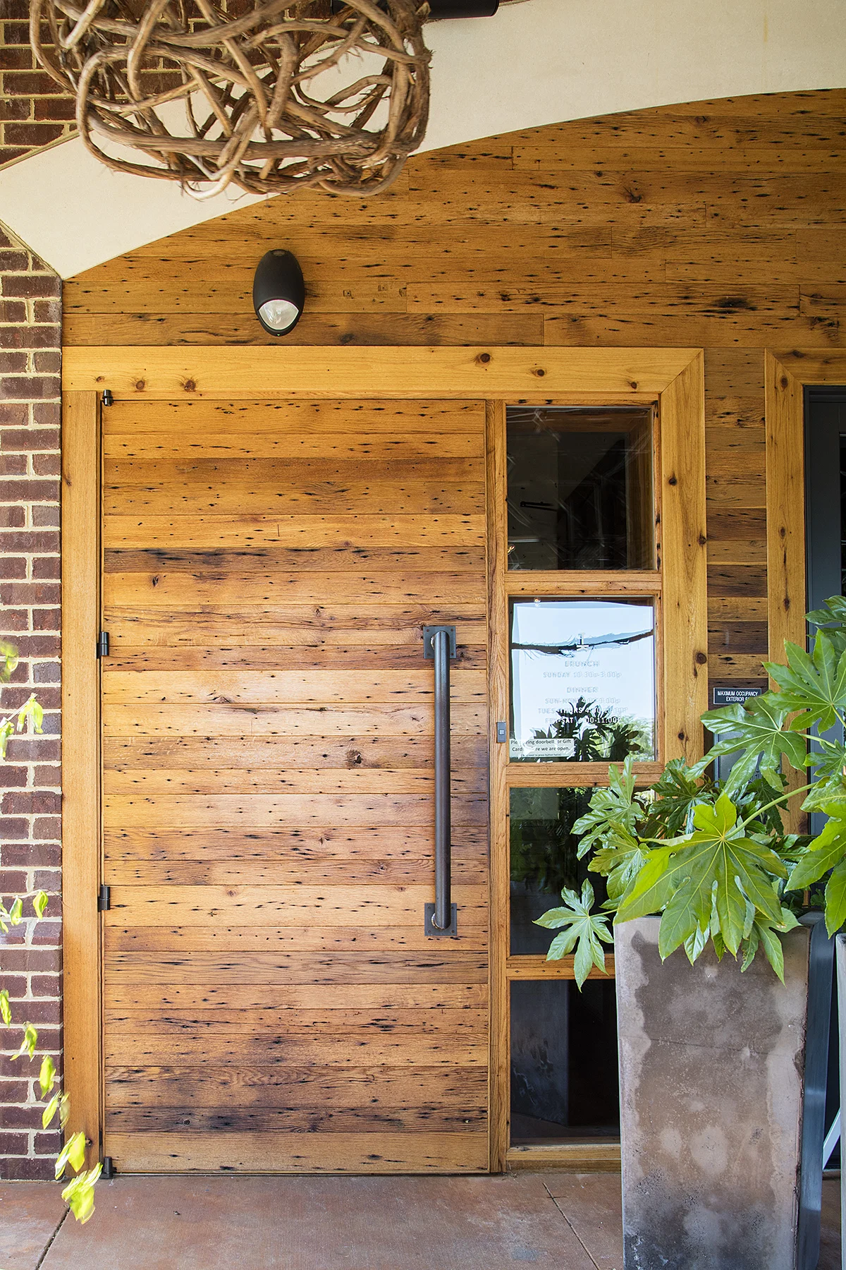 Photo: Alston Thompson Photography Knotty pine sourced by Surface Architectural Supply marks the entrance at Tazza Kitchen in Midlothian, Virginia.