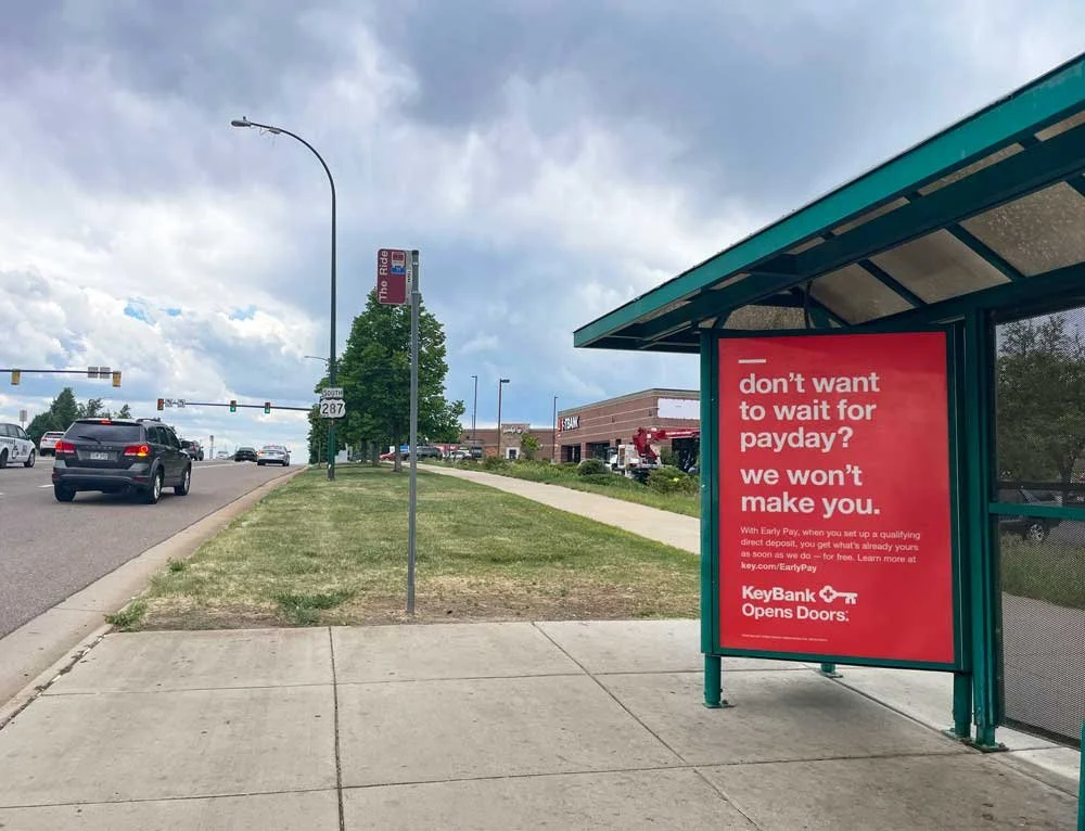 KeyBank bus shelter ad placed at a FirstBank branch location in the Denver metro, part of a hypertargeted outdoor advertising campaign