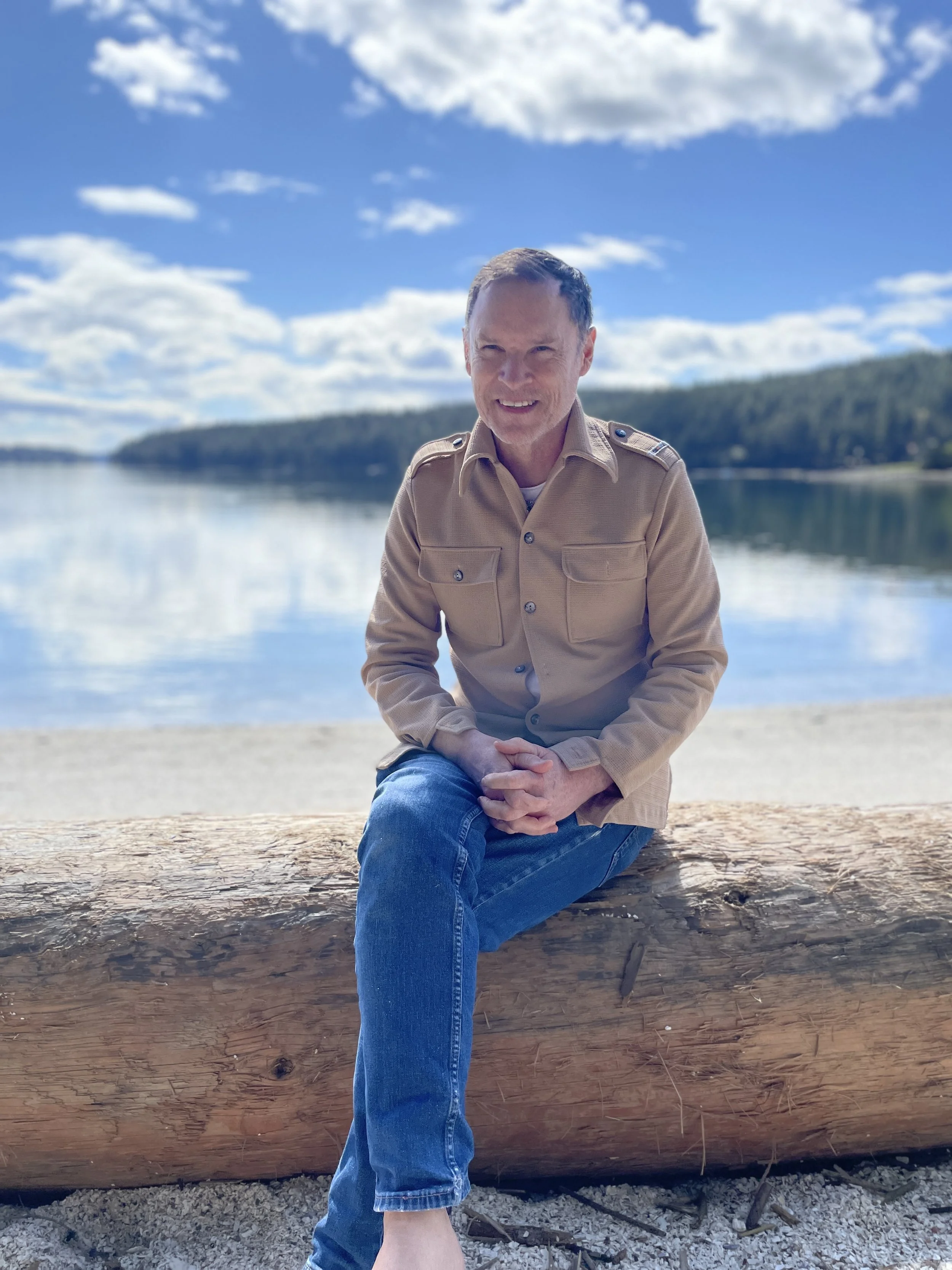 David sitting on a beach against a beautiful background