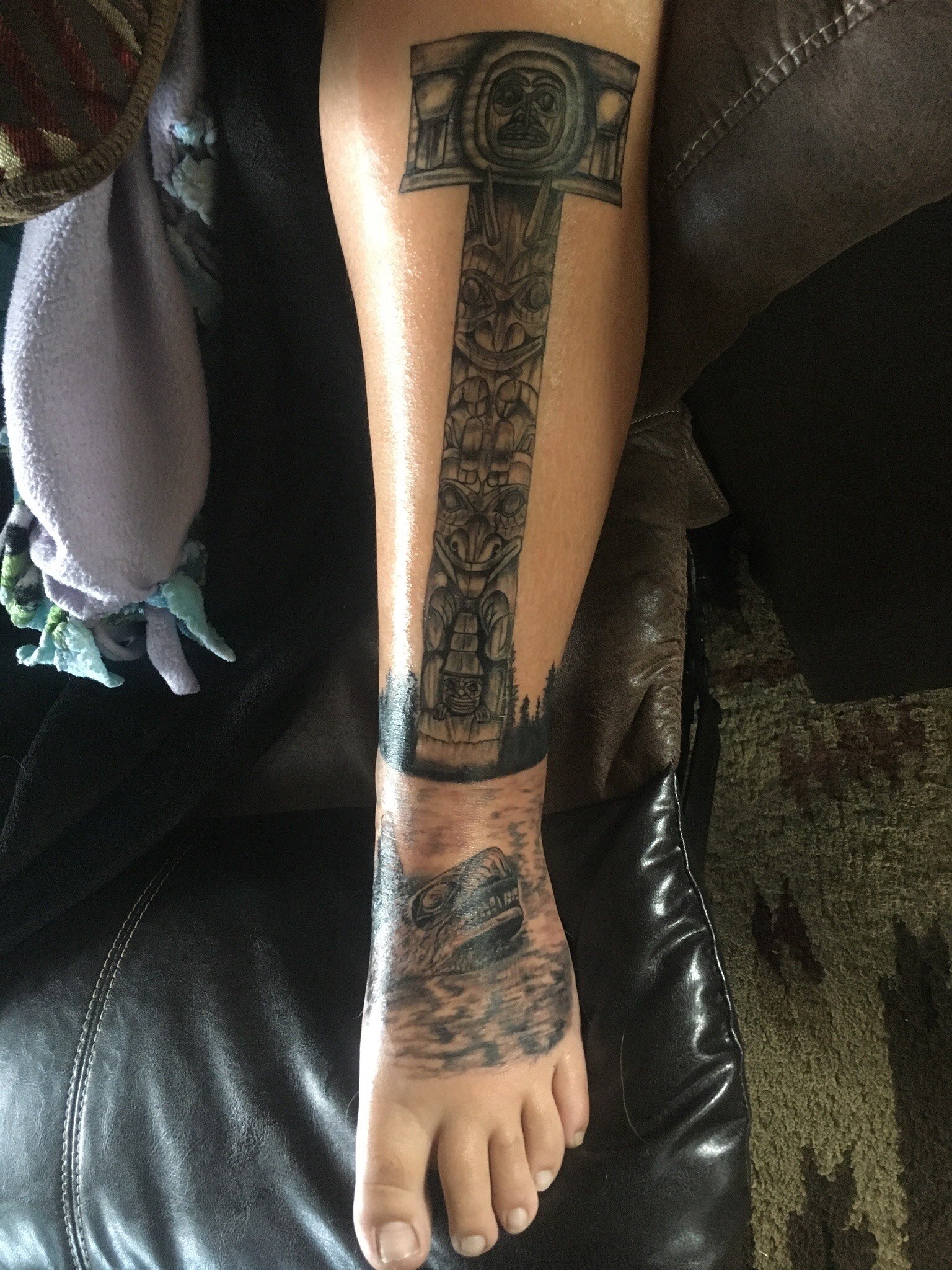Realism, totem pole on shin by Haida artist Gig at Liquid Amber Tattoo & Art Collective