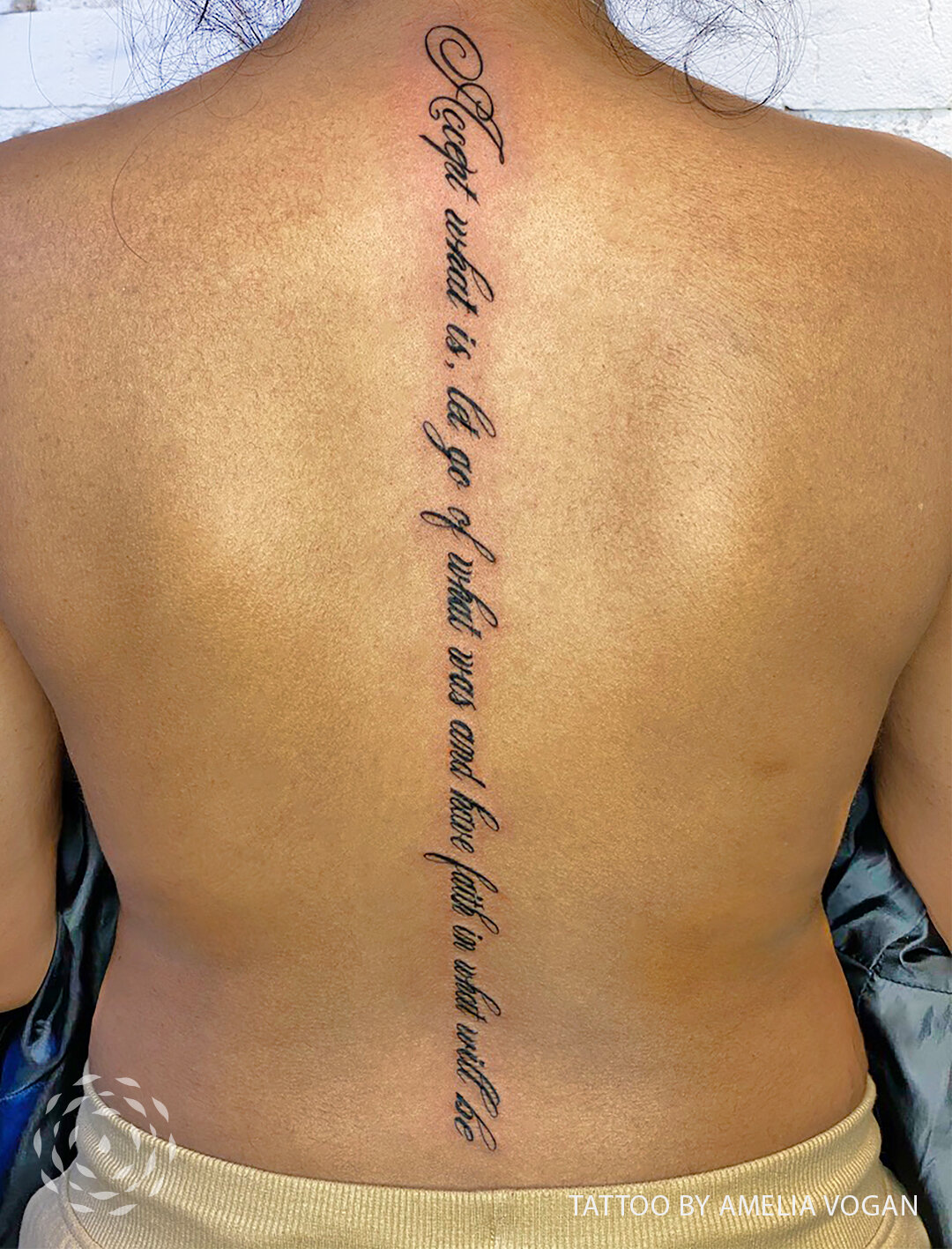 Script on spine tattoo by Amelia Vogan at Liquid Amber Tattoo & Art Collective