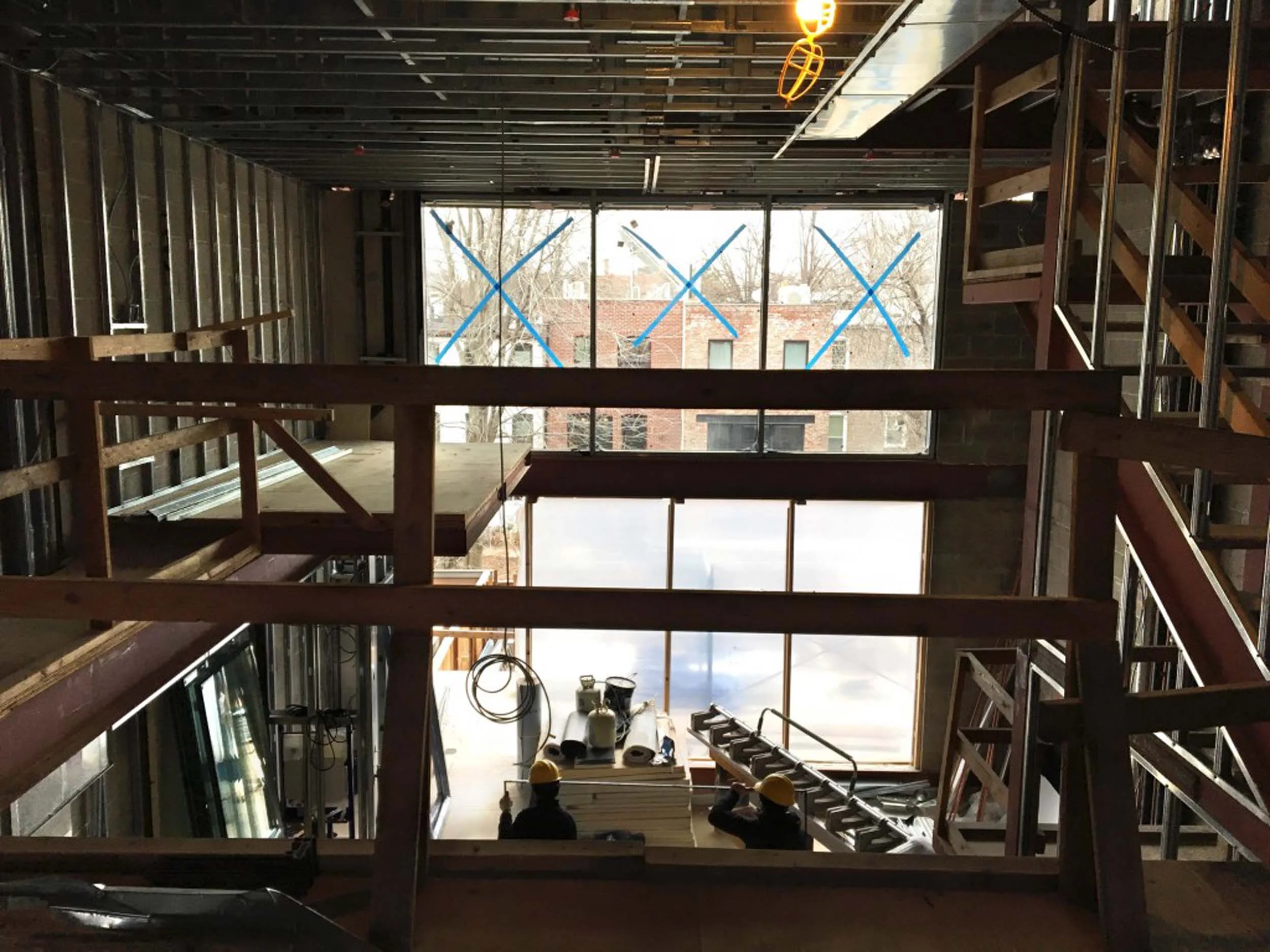 View of front facade from interior. Three large windows mark the entrance of the townhouse.