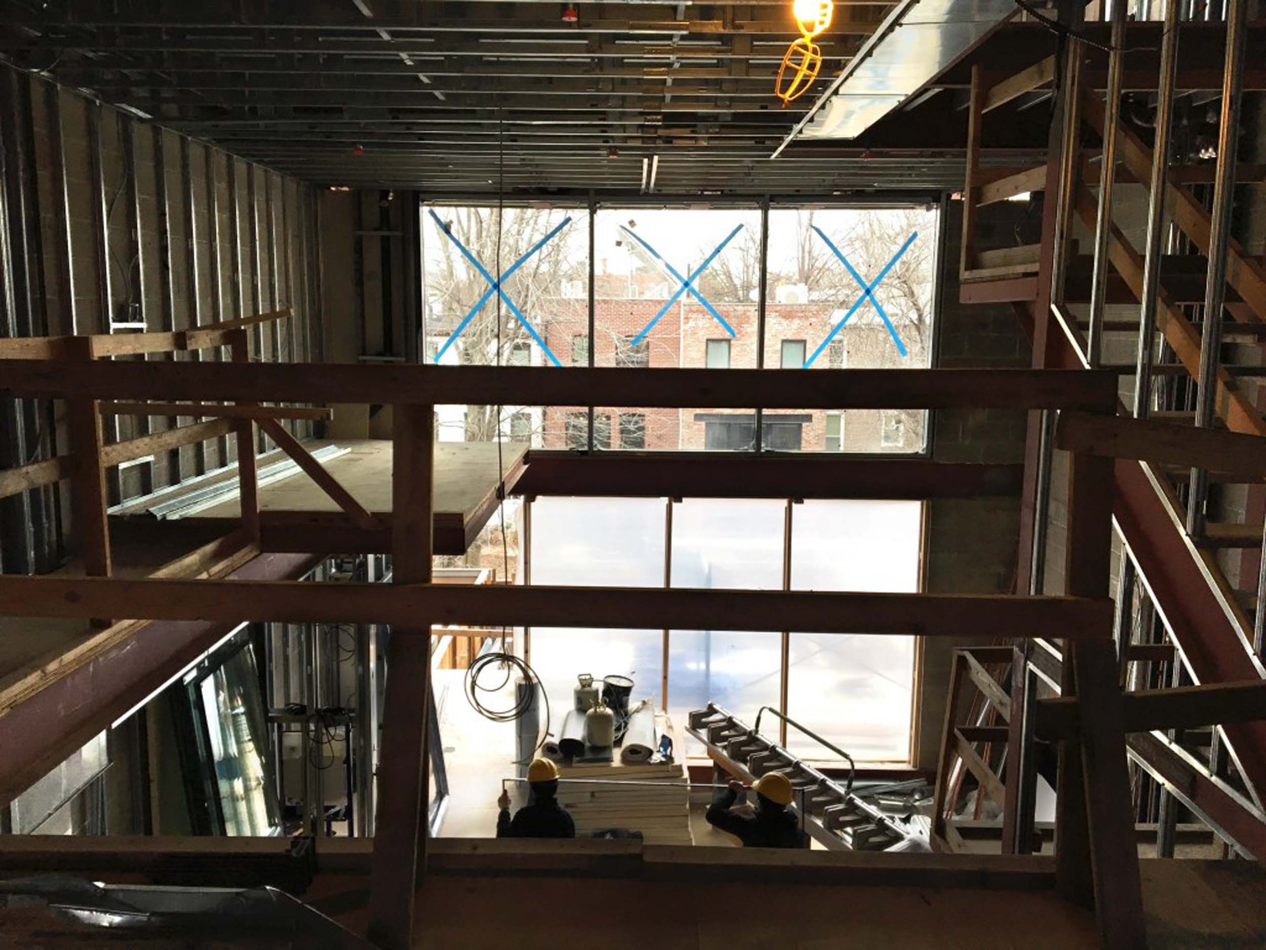   View of front facade from interior. Three large windows mark the entrance of the townhouse.  