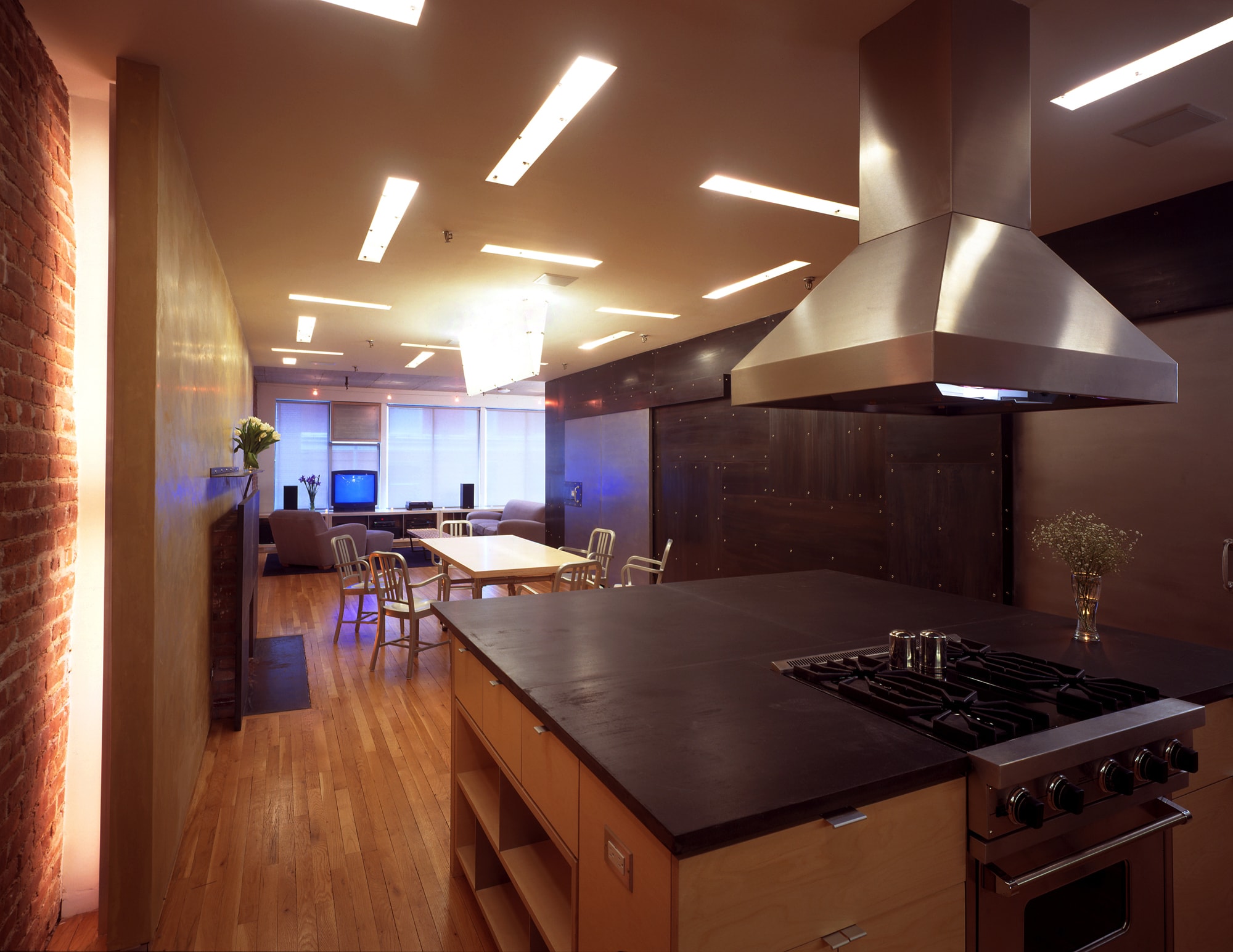 Modern Apartment Loft Renovation | Chelsea Manhattan New York City | Kitchen Island Black Countertop Custom Cabinets Stainless Steel Backsplash Black Steel Wall Fireplace | RES4