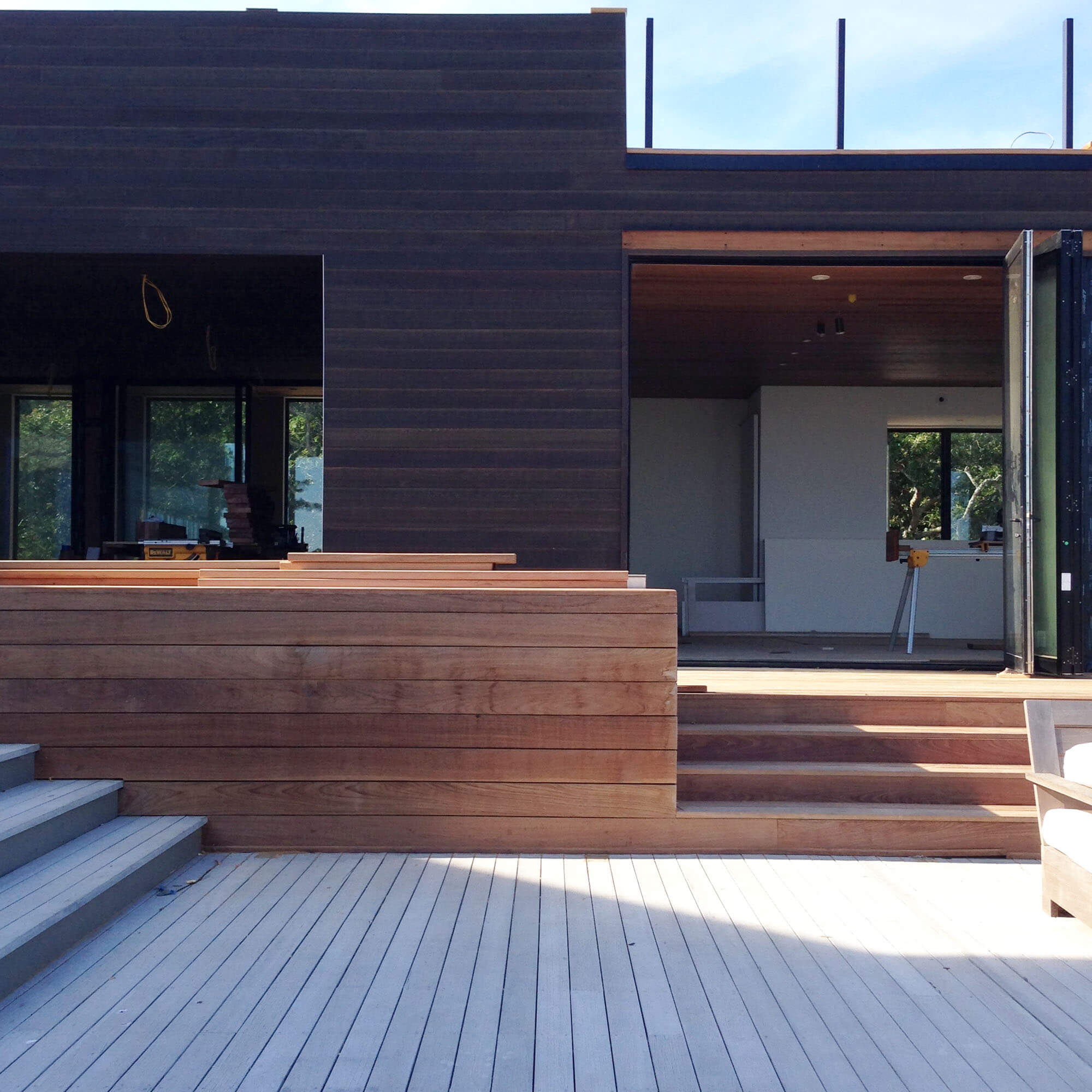   Exterior Bench  -  Ipe bench and risers align with the cedar edge and sliding glass doors beyond.  