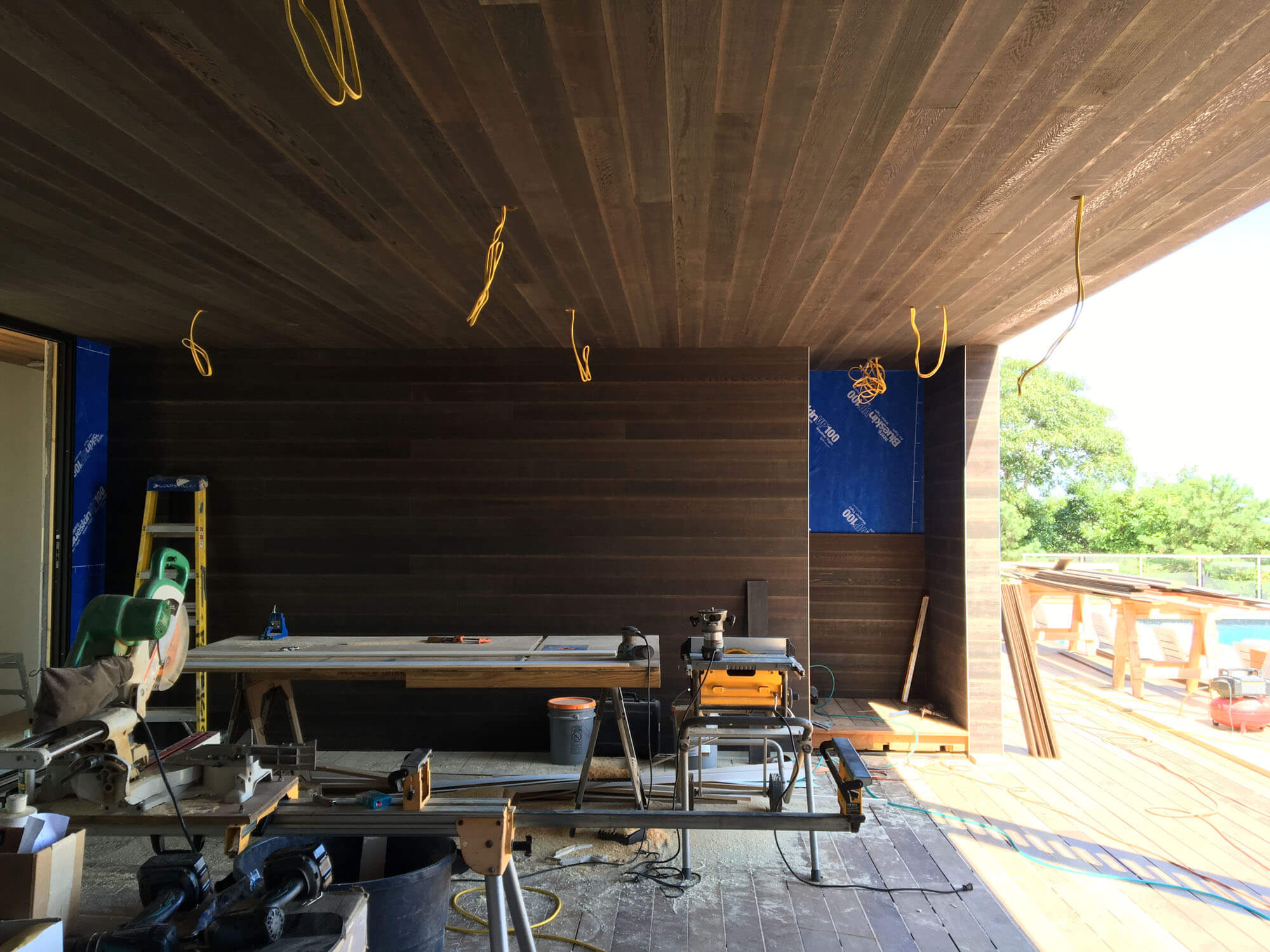   Enclosed deck space  -  A stained cedar wall separates a partially enclosed deck space from an exterior stair leading to the roof space.  