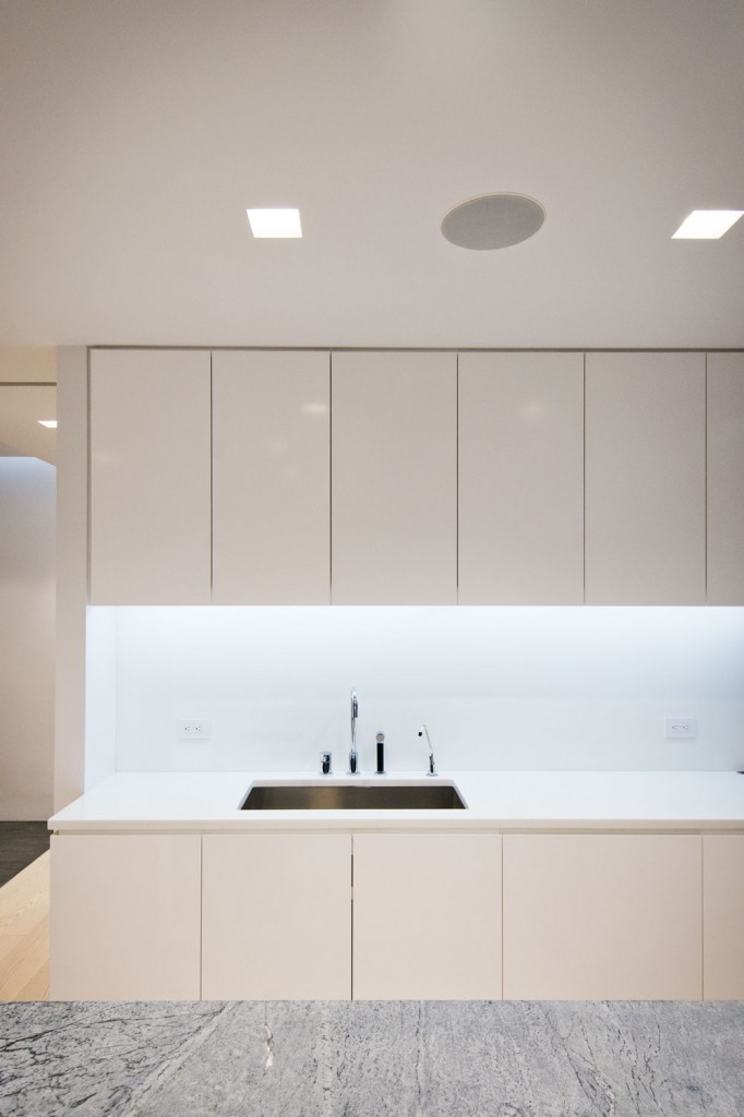   Kitchen  -  minimalist kitchen design with corian countertops and recessed accent lighting beneath kitchen millwork uppers.  