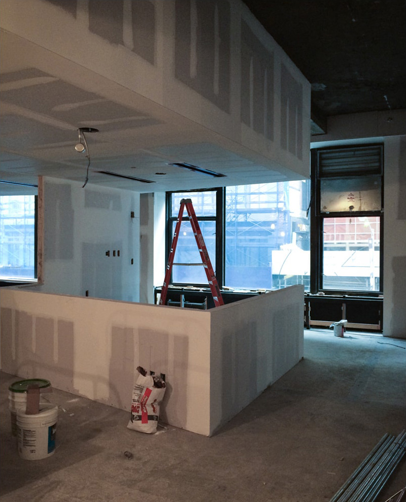   Sheetrock being applied to walls of office space  