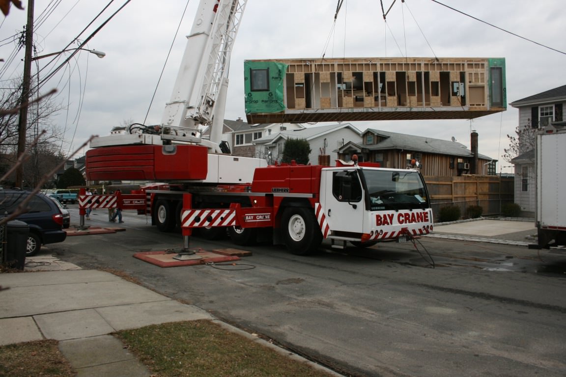   Crane lifting first prefabricated module into place.  
