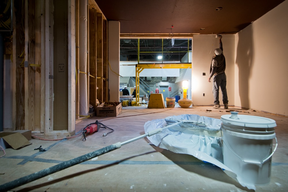   Worker Painting over the sheetrock  