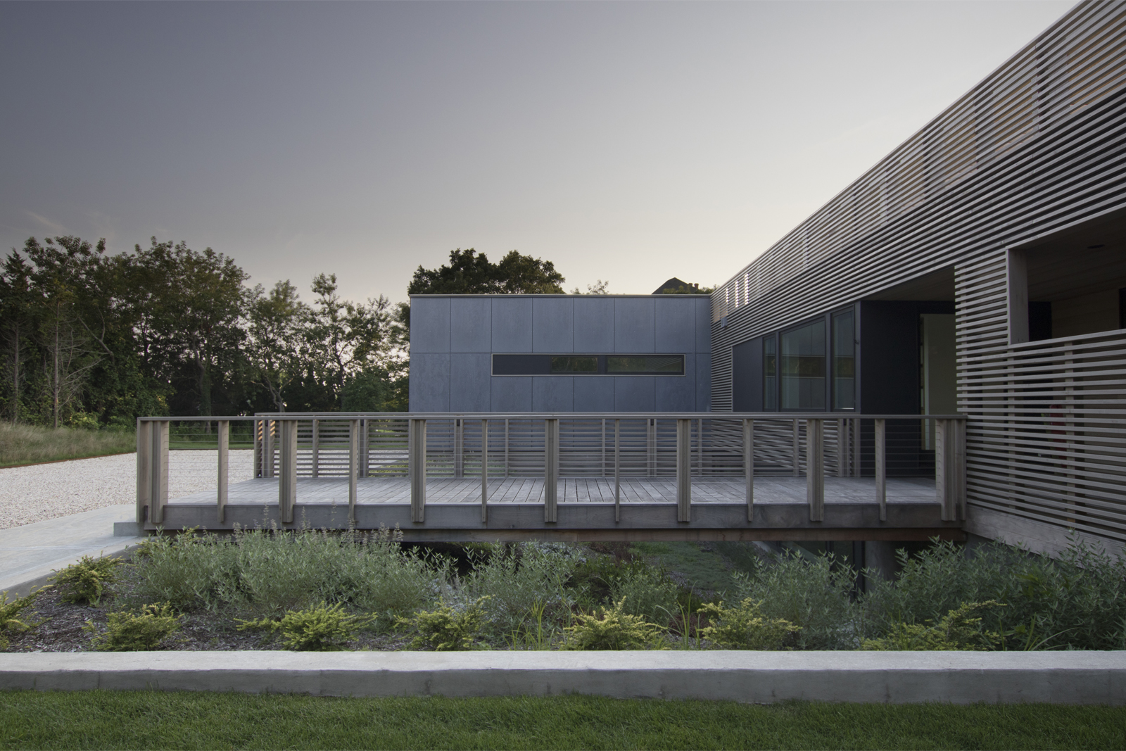 11-res4-resolution-4-architecture-modern-modular-house-prefab-home-north-fork-bluff-house-exterior-facade-elevation-bridge-entry-dusk.jpg