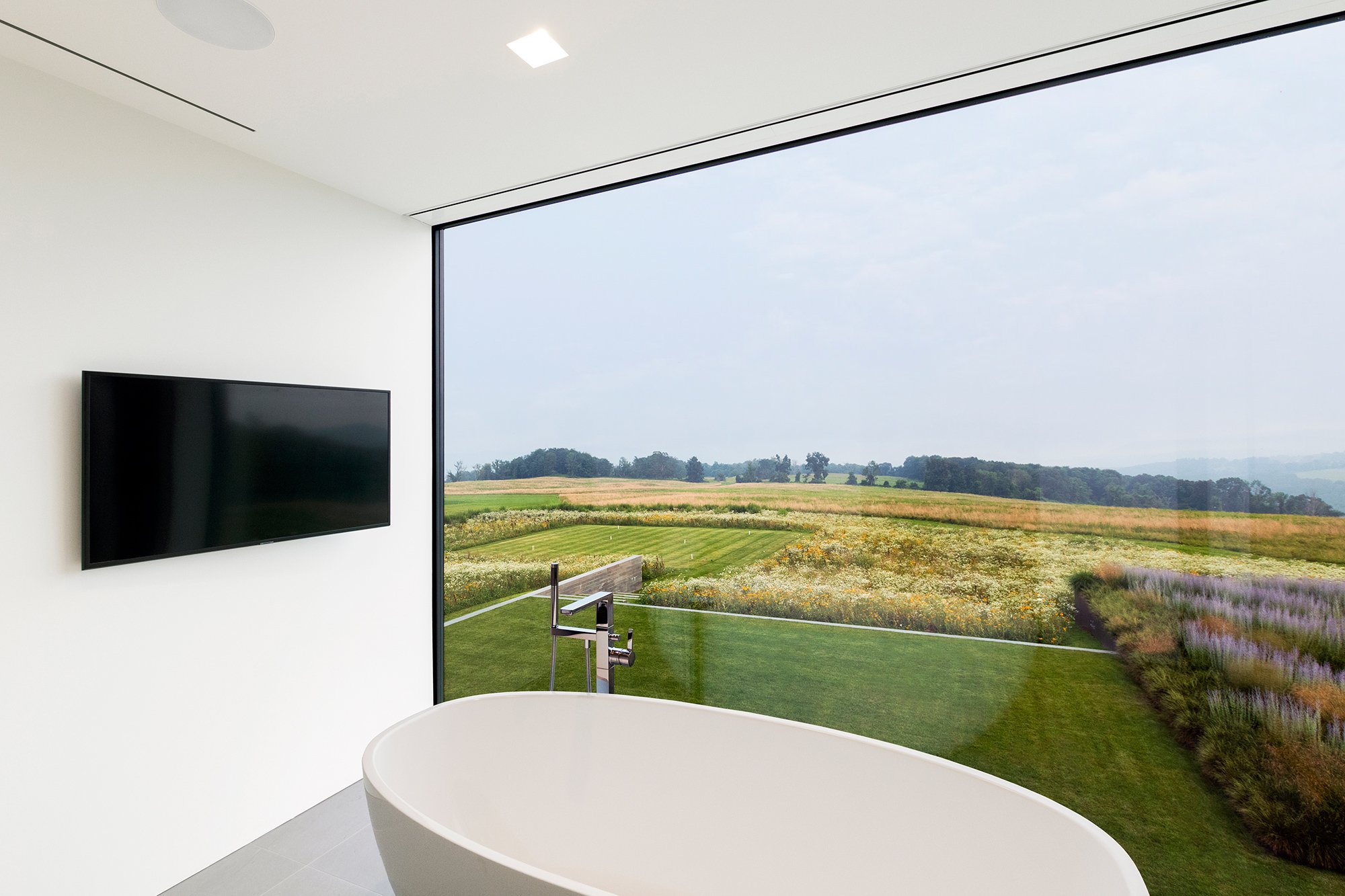 48_res4-resolution-4-architecture-millbrook-residence-modern-home-new-york-hudson-valley-custom-high-end-residential-his-master-bathroom-bathtub-view.jpg