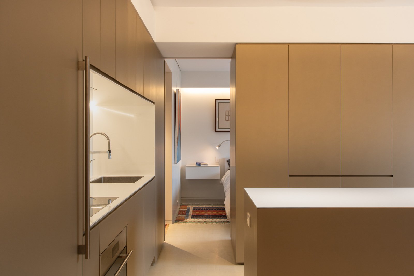 11-res4-resolution-4-architecture-modern-apartment-renovation-nyc-pied-a-terre-kitchen-custom-island-cabinets-metallic-millwork-built-ins-hidden-pocket-doors-bedroom.jpg