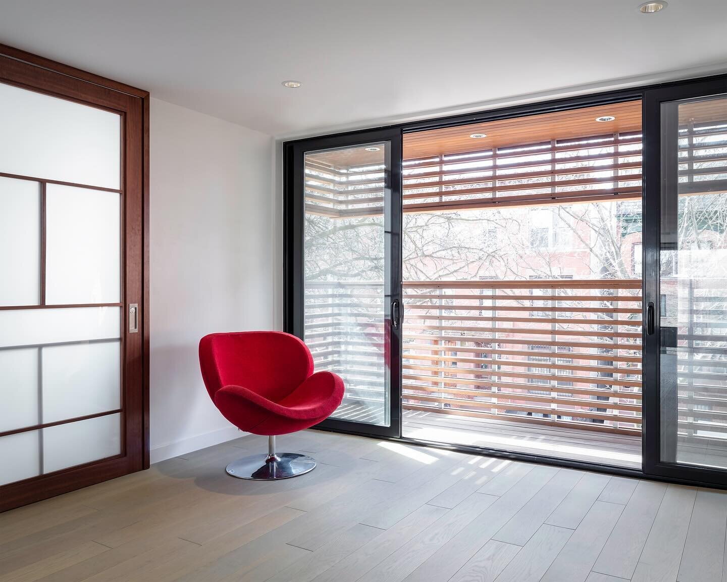 A study is tucked into a corner with the mezzanine level opening to a balcony facing the street, wrapped in cedar slats for privacy. 

The open-tread stair wrapping the black steel-clad wall link all five levels of the townhouse and become a focal po