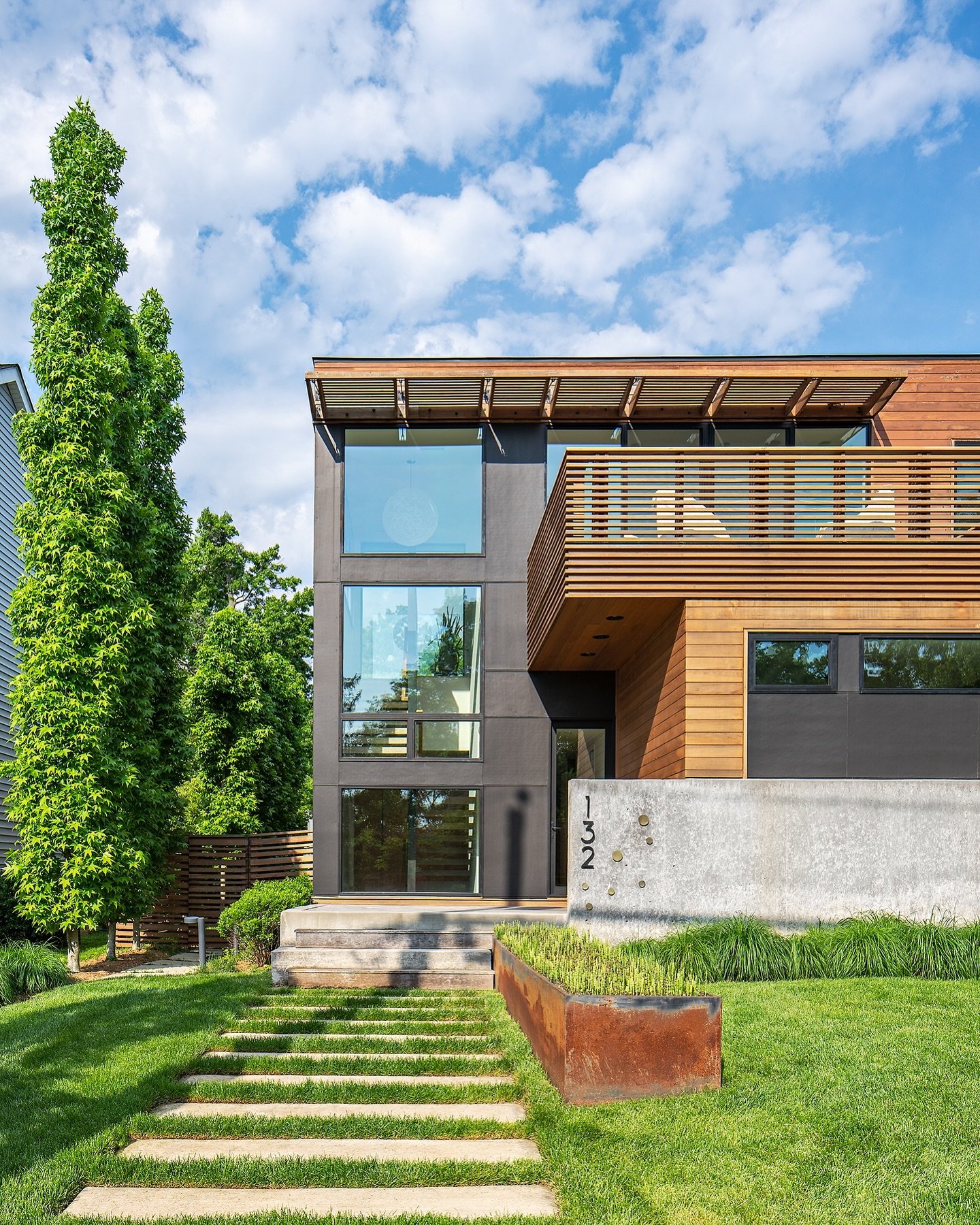 As you approach the front porch, on axis with the primary stair, the front door is revealed off to the side, below the shelter of a second-floor deck above.

To see more of this project check out the North Filmore Residence on our website (which can 