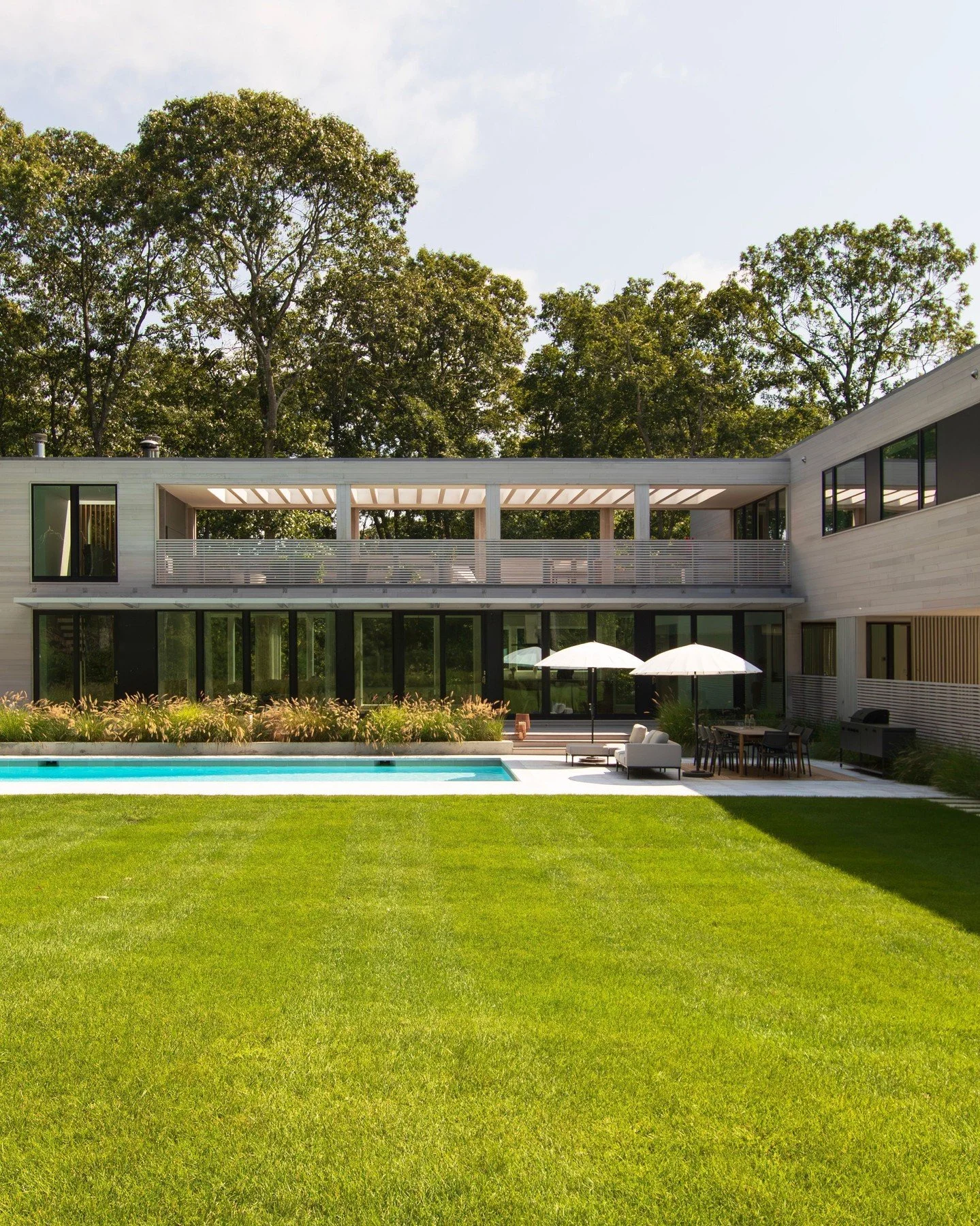 We're excited to share a first look at our latest MODERN MODULAR prefab - a summer home designed for a young family of five and their extended family. 

Upon arrival, the carport, formed by second-story modules spanning above, invites you into the pr