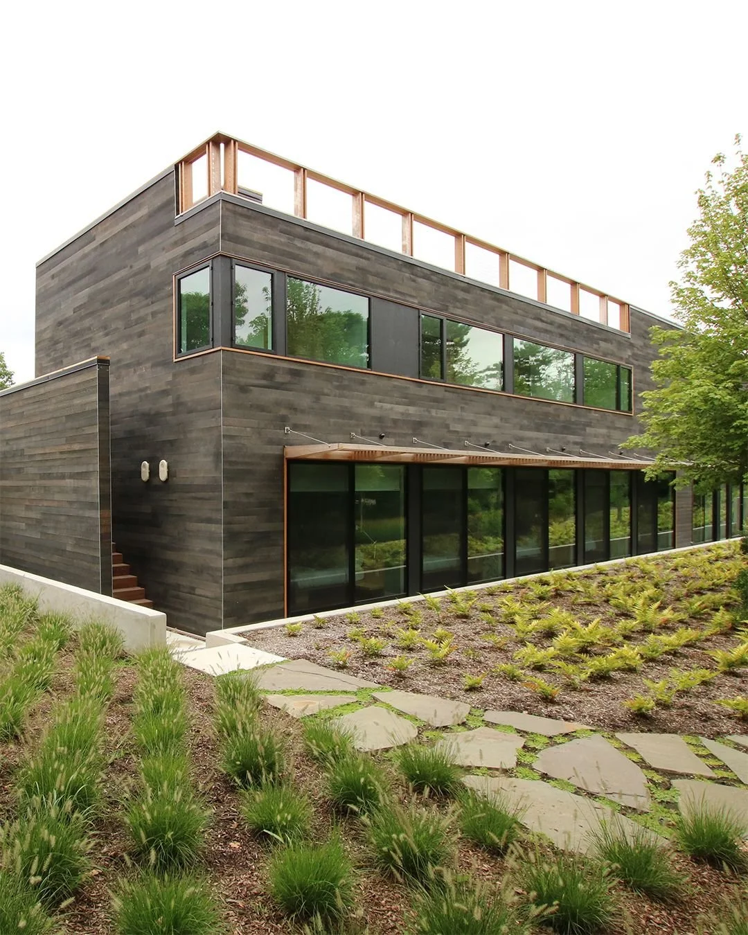 Perched above the ocean, this 5,000-sf modular guest house was designed for summer gatherings &mdash; extending the owner's existing beach home into a retreat made for entertaining.

Floor-to-ceiling glass walls, folding doors, and a rooftop deck wit