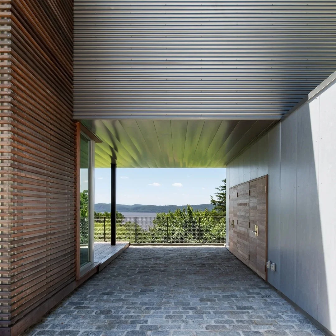 At Hudson River House, the view begins before you enter.

The approach passes beneath the house and frames the Hudson through the carport. On the main level, floor-to-ceiling glazing opens the living spaces to the panorama.

At under 2400sf, the site