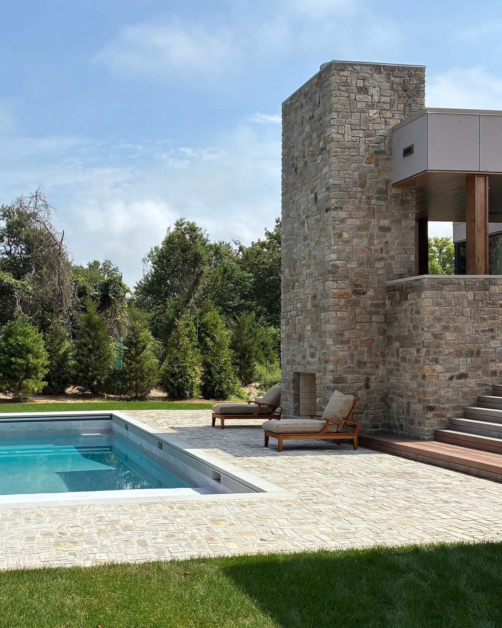 Over the last couple months we've watched the finishing elements come together at our MODERN MODULAR Cutchogue Bluff House. Stone on the facade and pool terrace, laid one-by-one, adds warmth, texture, and depth to this prefab home. Landscaping by @su